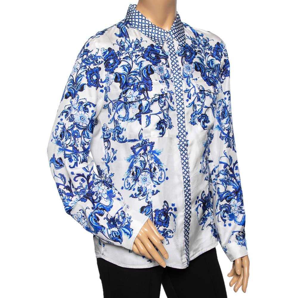 Questa camicia di Roberto Cavalli è all'insegna del comfort e dell'eleganza. Realizzato in seta, presenta stampe floreali blu su una base bianca e maniche lunghe con colletto classico. Completo di chiusura con bottoni, si abbina a fondi neri. 