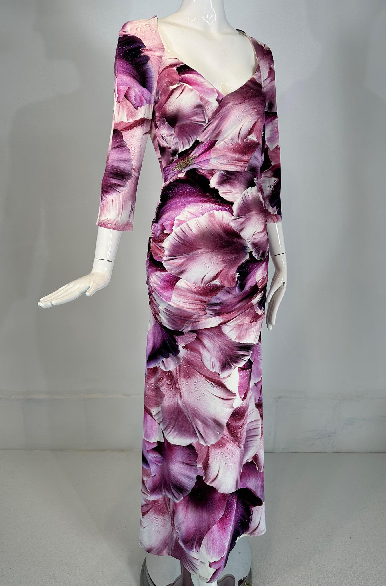 Roberto Cavalli maxivestido de pétalos de rosa vino de fantasía, drapeado lateral con un aplique de strass plateado bajo el pecho derecho. Profundo escote en V con sobrepelliz. De manga larga, el vestido es entallado y drapeado por el torso. El