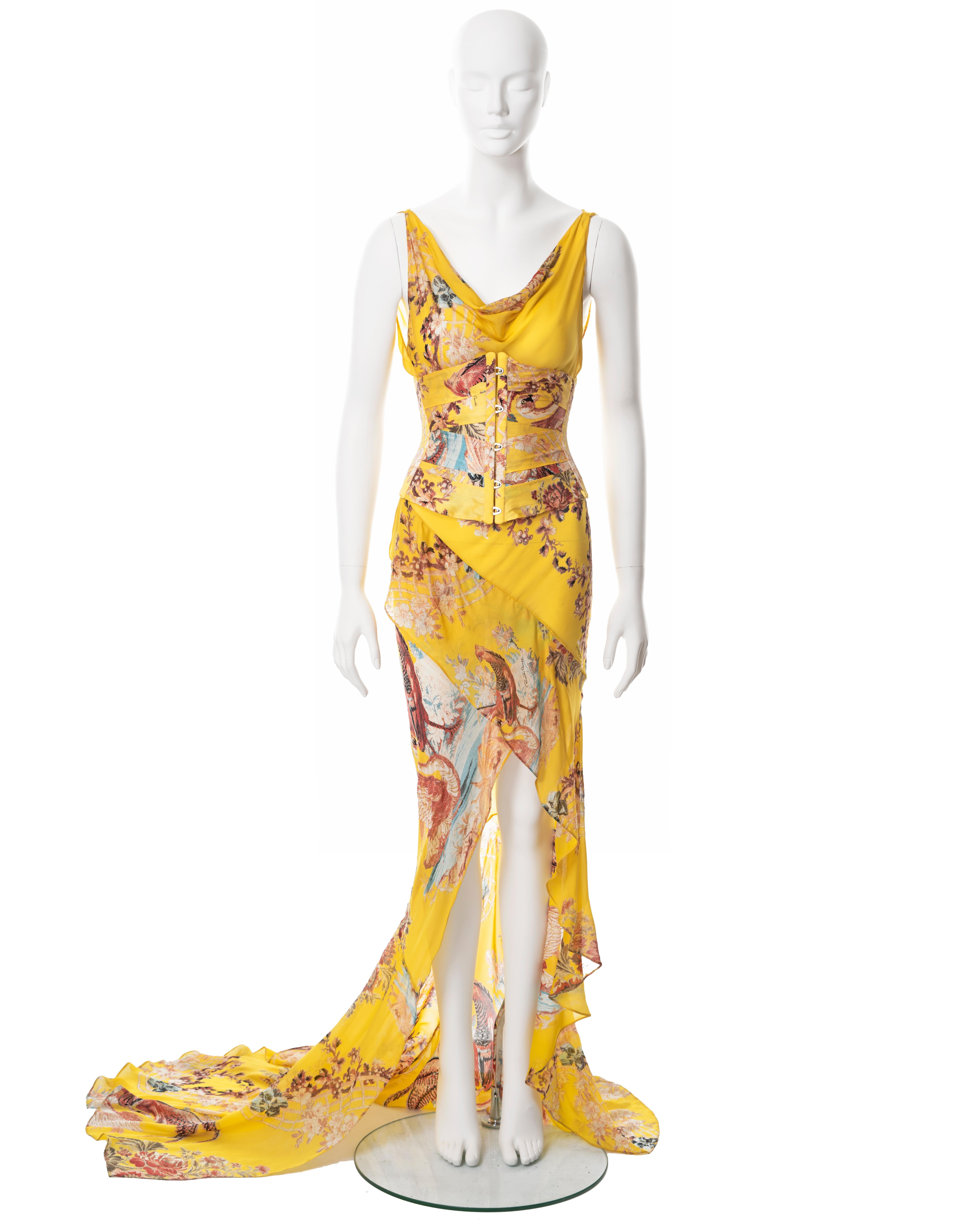 ▪ Roberto Cavalli evening dress and corset 
▪ Sold by One of a Kind Archive
▪ Spring-Summer 2003
▪ Constructed from yellow bias-cut silk with pink and blue floral print 
▪ Cowl neck
▪ High-low floor length skirt with train 
▪ Sold with matching
