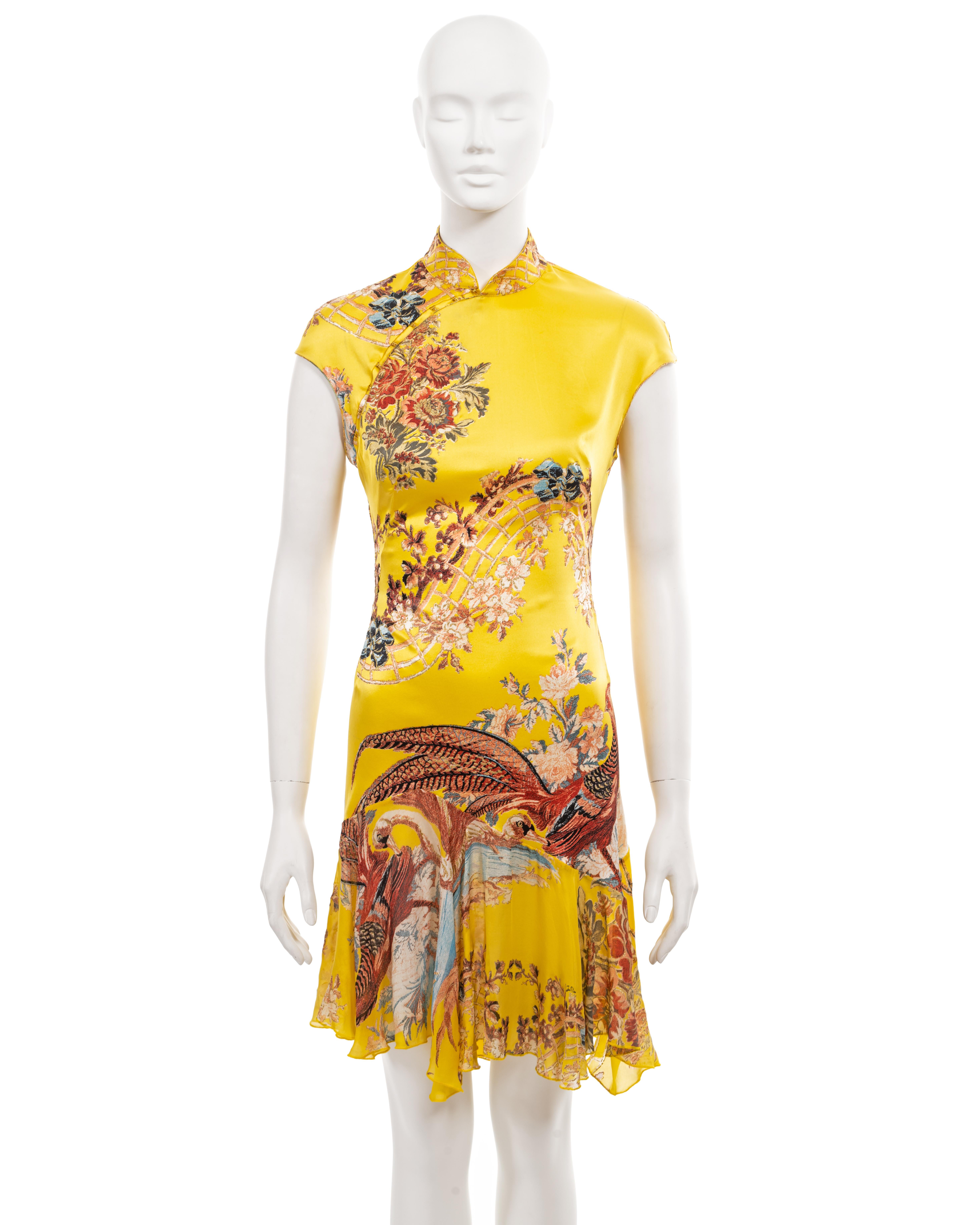 ▪ Roberto Cavalli archival dress
▪ Sold by One of a Kind Archive
▪ Yellow silk with floral and bird motifs in shades of blue and pink 
▪ Mandarin collar
▪ Cap sleeves 
▪ Cutout at the centre back  
▪ Silk chiffon mini skirt with asymmetric hemline