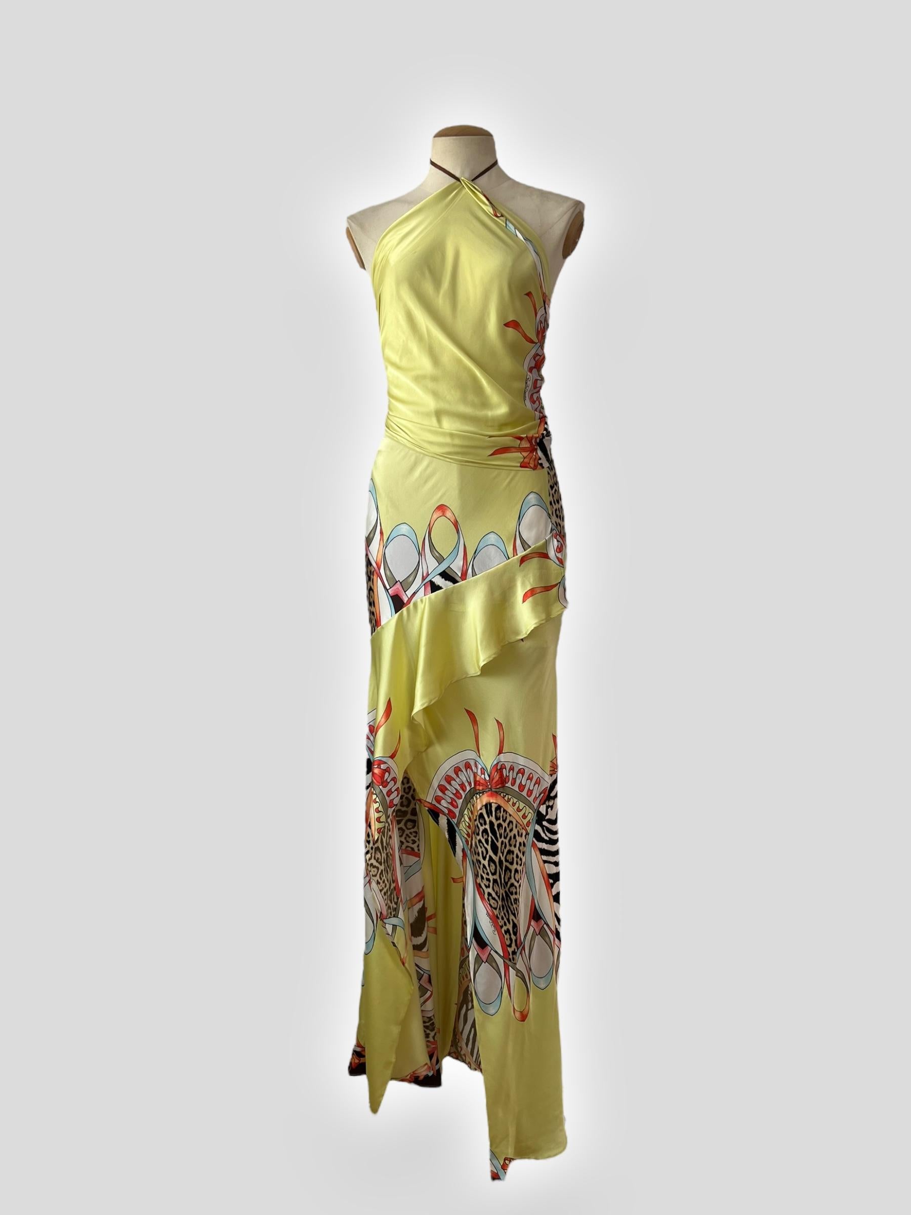 Un ensemble deux pièces de la collection printemps/été 2004 de Roberto Cavalli, composé d'une soie jaune vibrante ornée d'un imprimé guépard et d'un motif équestre. L'ensemble comprend une jupe maxi à volants fluide et un haut à foulard assorti, qui