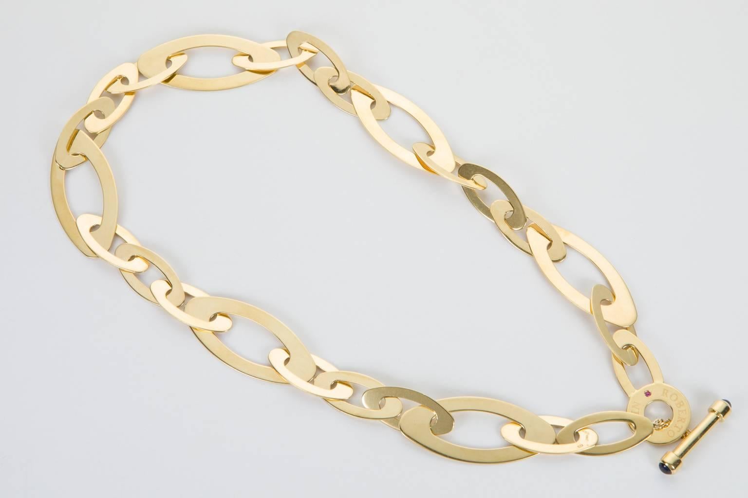 Sleek and stylish, this 18k Yellow Gold Roberto Coin necklace is such a beautiful statement. Large oval shaped flat links make for an interesting look on the neckline and with movement they have a certain shine. Signed Roberto Coin on the front