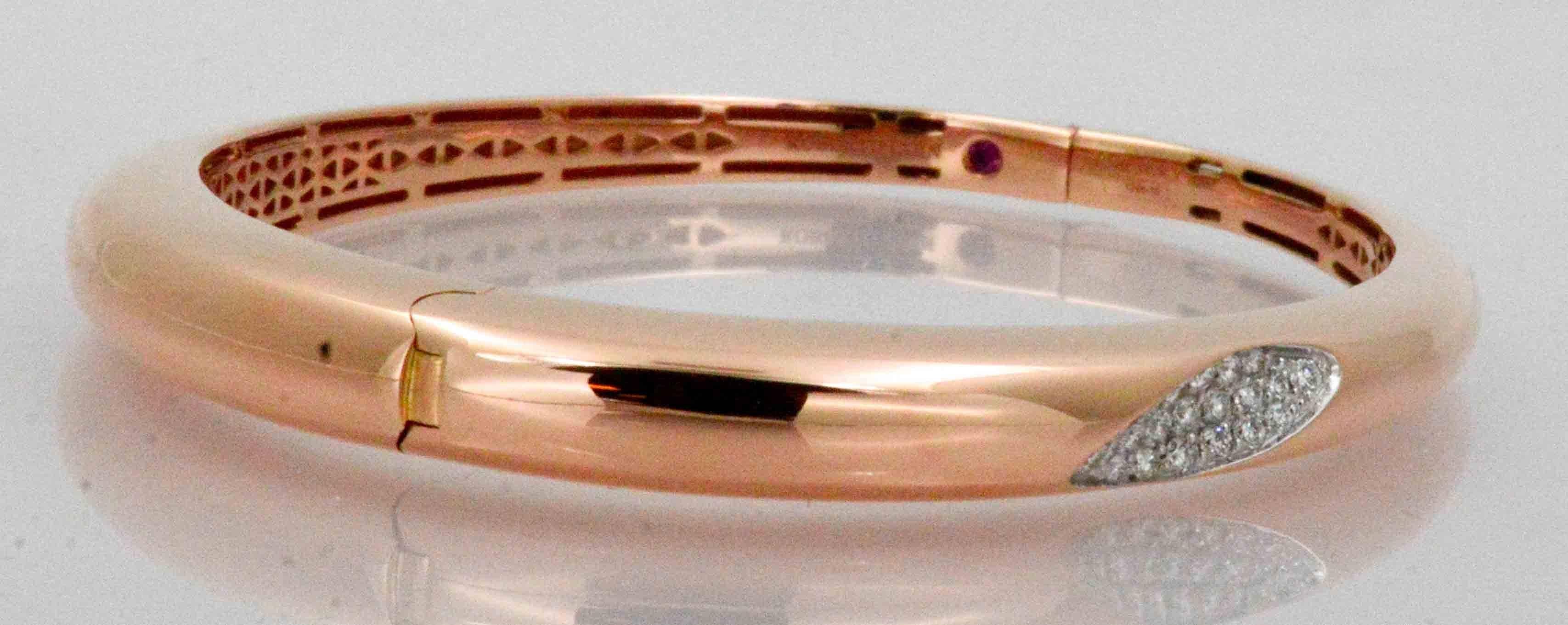 Starring an Italian Roberto Coin rose gold hinged bangle bracelet, this gorgeous bracelet  spotlights .30 ctw diamonds (G color, VS internal clarity) in a pave set accent. This alluring rose gold bracelet is tapered in a sleek design, and hinged for