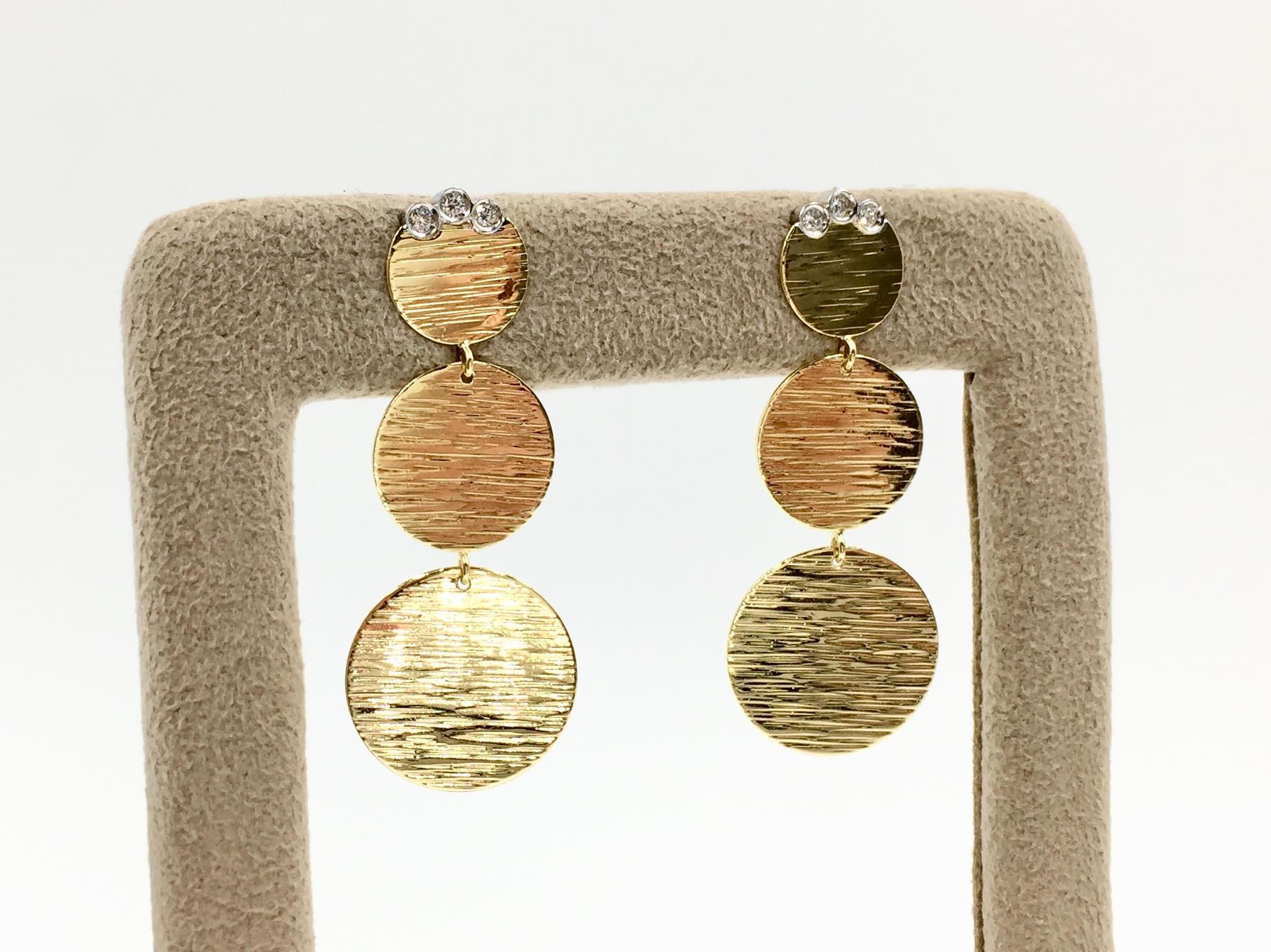 Flirty and fashionable, Roberto Coin 18k yellow gold graduated disc earrings each with 3 bezel-set round diamonds weighing approximately .12 carats total weight. The discs are connected by a delicate link to allow movement - not at all stiff.