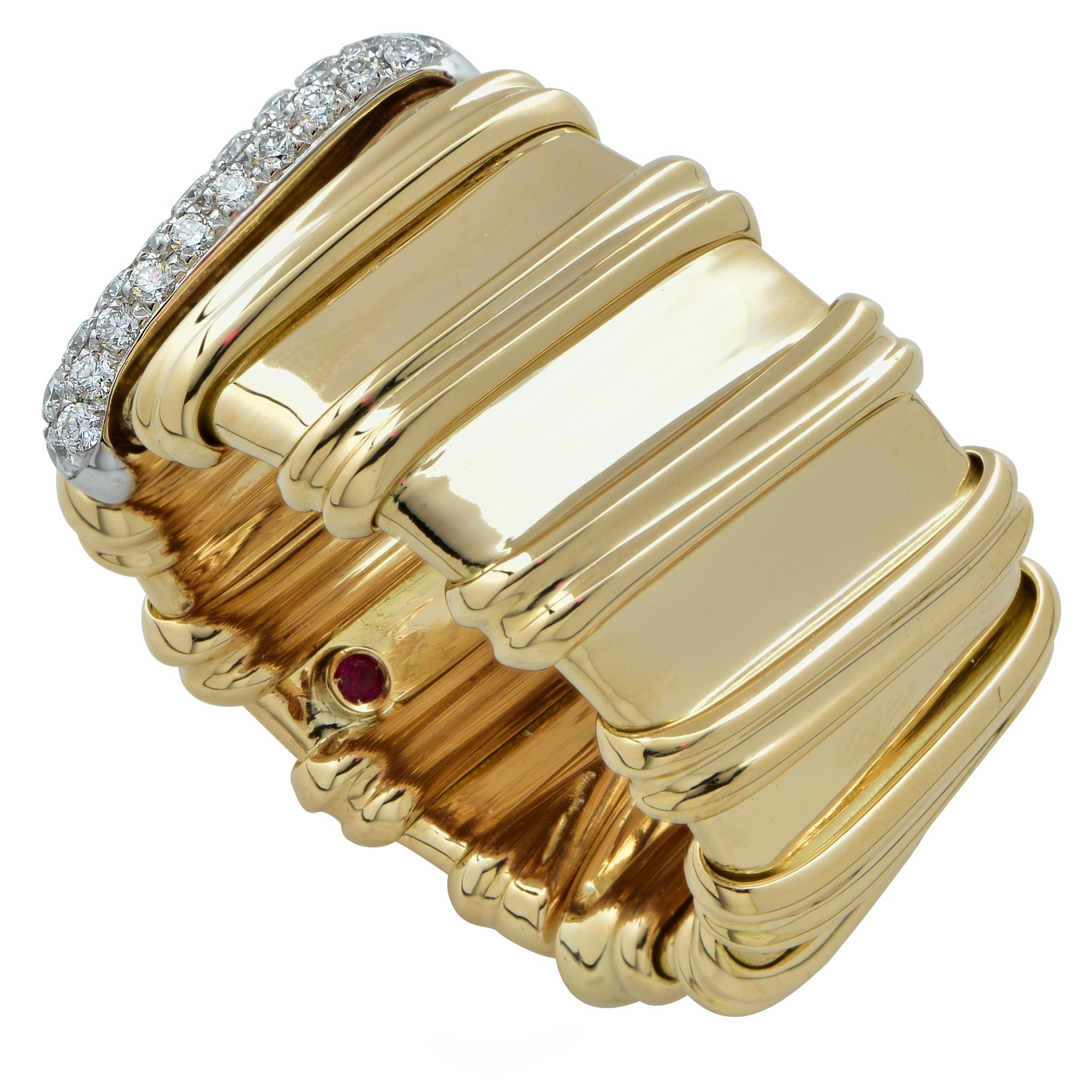 Stunning Roberto Coin Flexible band crafted in 18K yellow gold featuring twelve gold double line accents, one of which is adorned with 31 round brilliant cut diamonds weighing approximately .21 carats total weight, in a pave’ setting. Featuring the