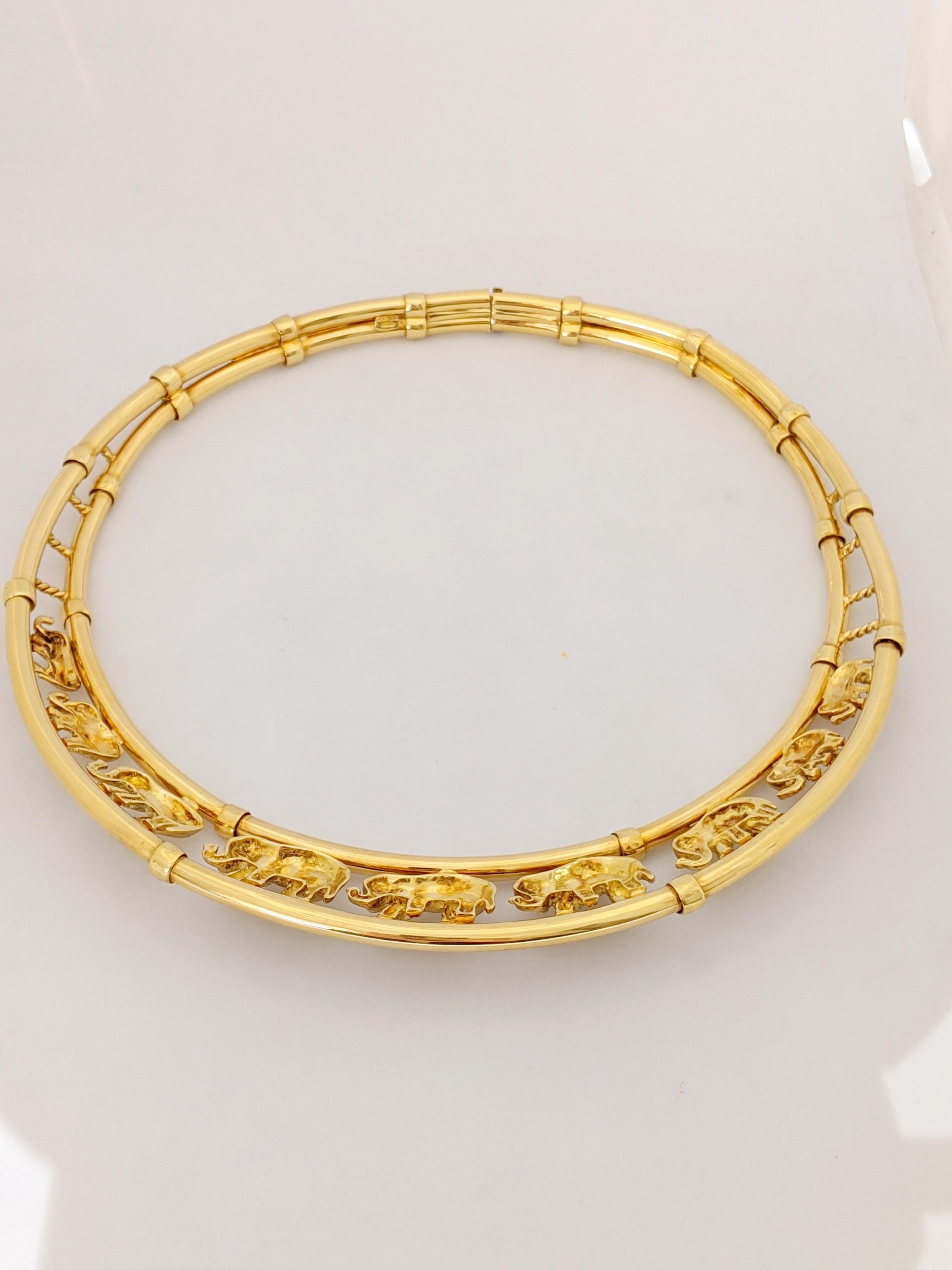 Classic collar necklace from Roberto Coin of Italy.
Nine graduating elephants, each with a round brilliant Diamond eye are the centerpiece of this 18 karat yellow gold collar. The elephants have their noses up which is symbolic of 