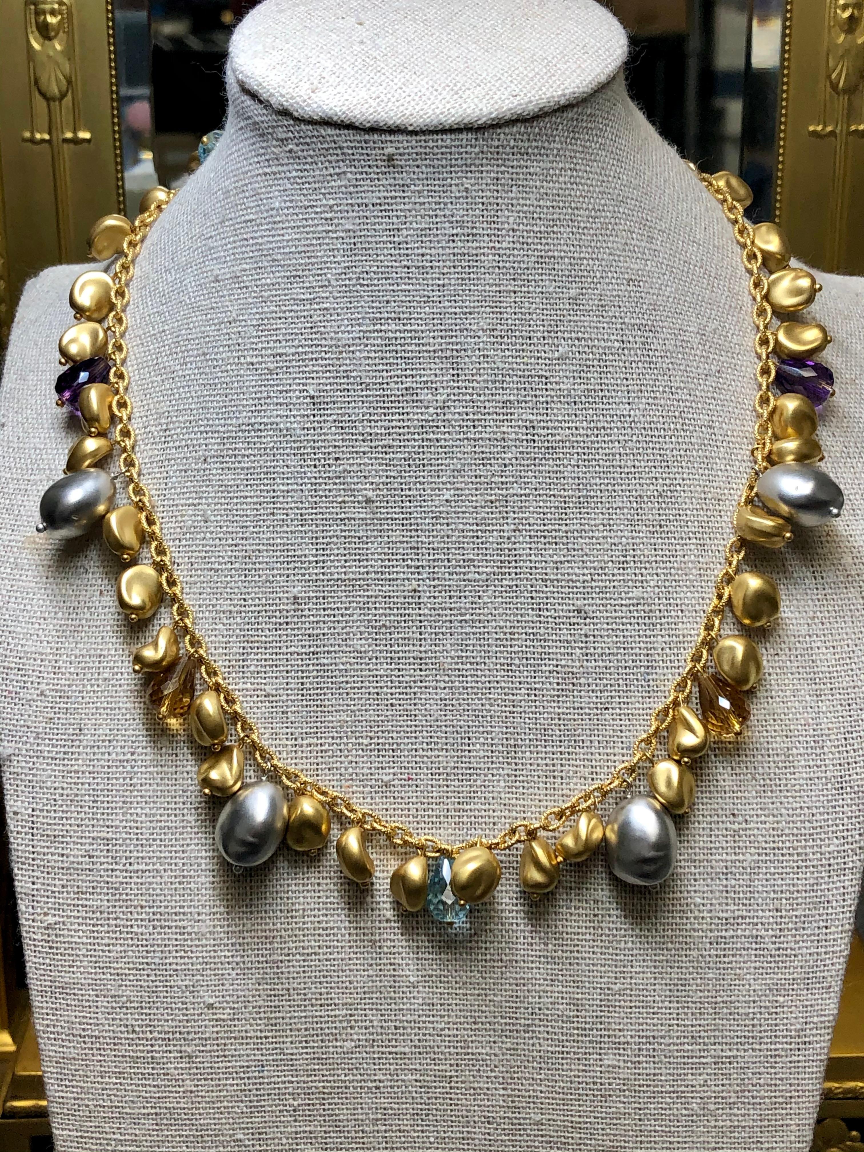 A contemporary necklace done by designer ROBERTO COIN hand crafted in 18K white and yellow gold and finished with faceted, briolette natural topaz and amethyst. Each nugget of gold is gorgeously satin finished and perfectly spaced throughout the