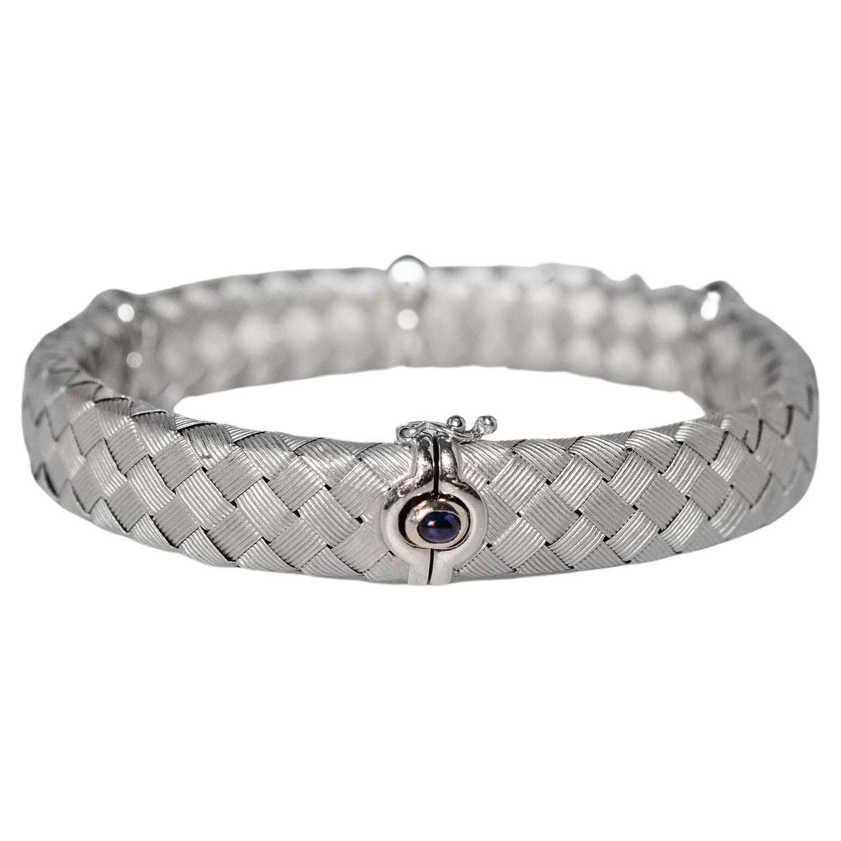 Roberto Coin bracelet with diamonds set in a 18k solid white gold band. It has .40 carats of G color diamonds beautifully displayed in three bands. Safety clasp has a Blue Cabochon Sapphire. Roberto Coin is stamped inside the bracelet. We do not