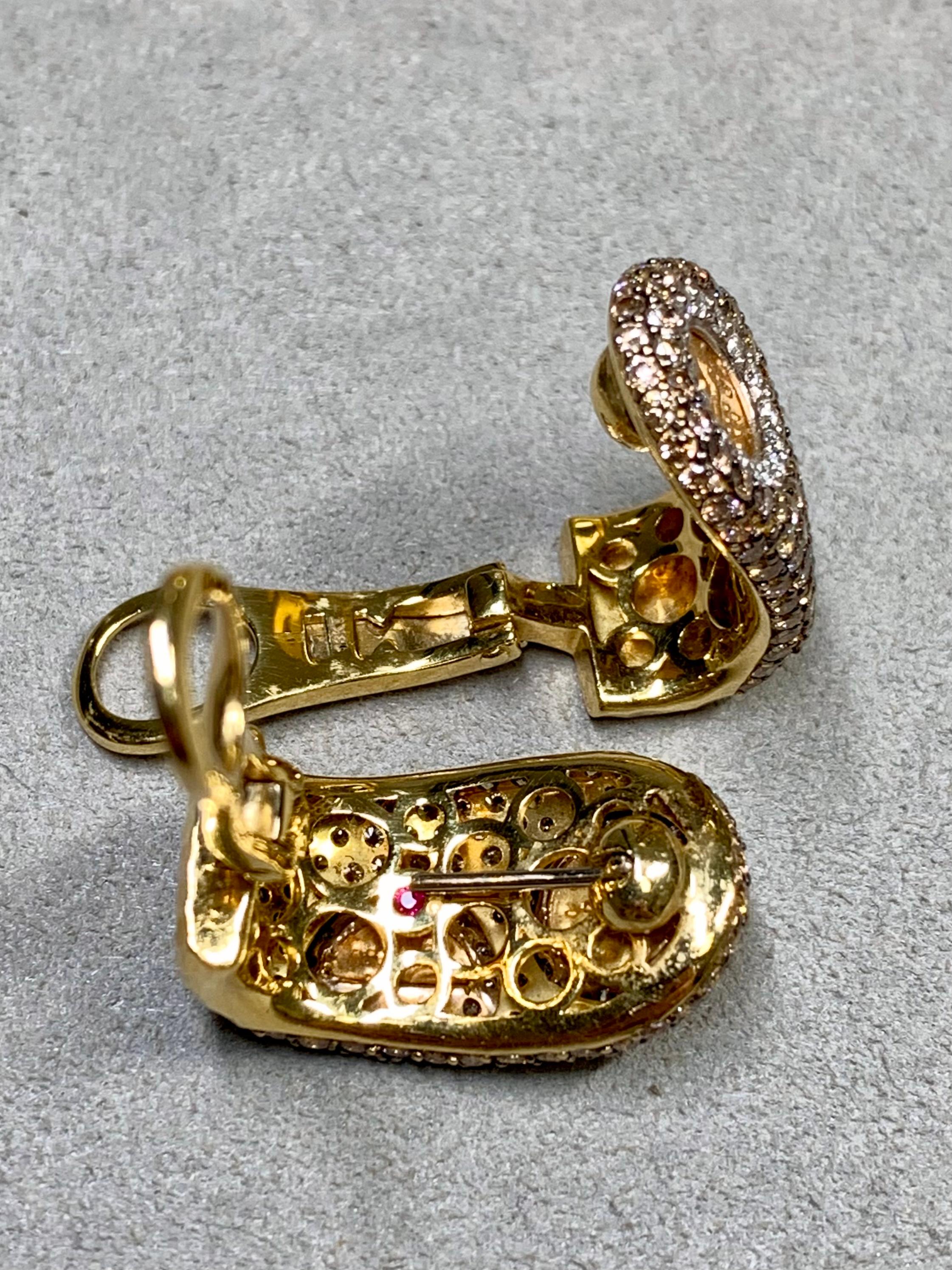 A contemporary pair of huggie earrings done in 18K yellow gold by Roberto Coin. They are pavé set with approximately 4ctw in natural fancy brown and white diamonds and have swing-up posts with omega backs.


Dimensions/Weight:

Earrings measure 1”