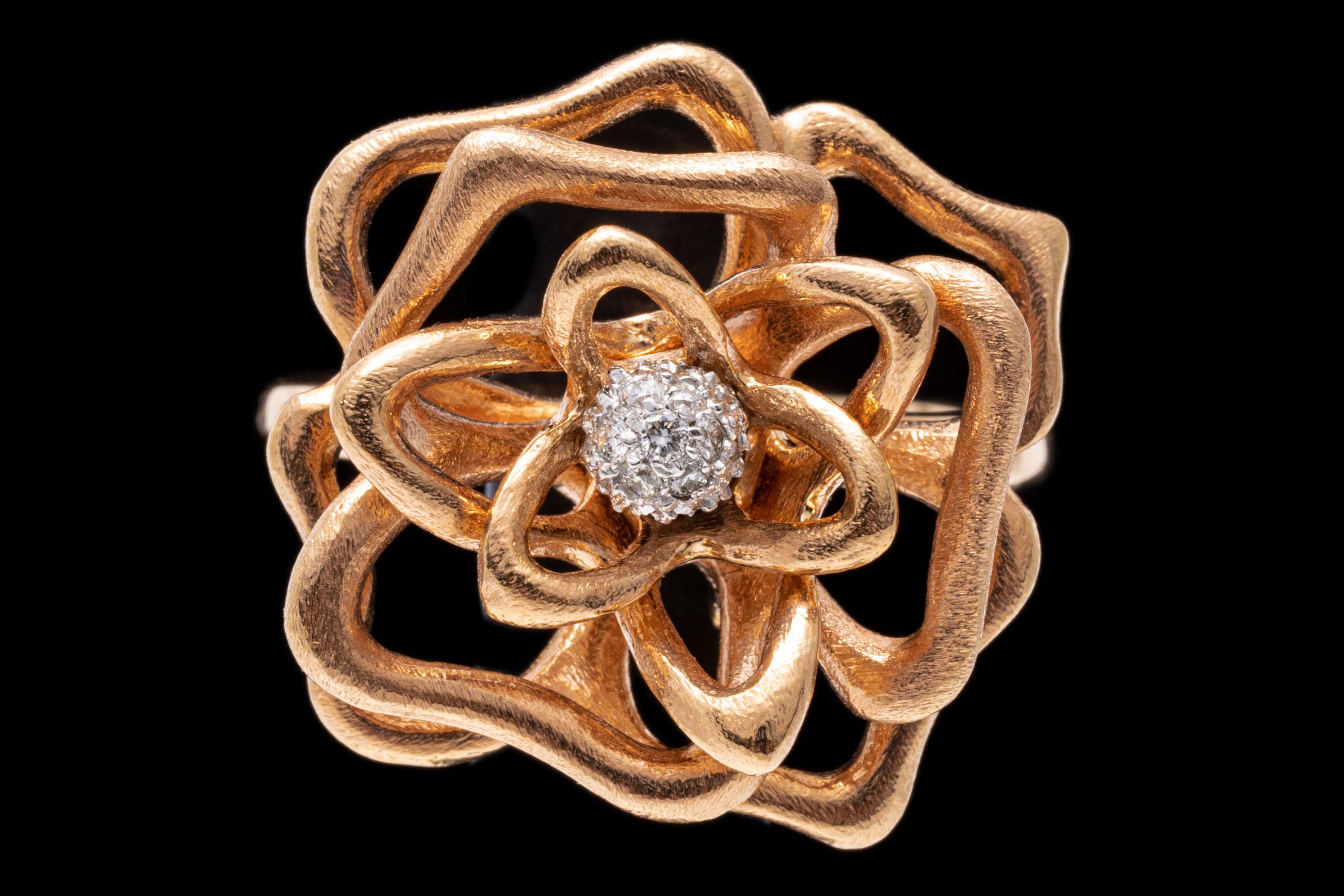 18k rose gold ring. This delightful ring by Roberto Coin is a an open figural rose motif, set in the center with a pave set cluster of round faceted diamonds, approximately 0.10 TCW. The ring is decorated on the underside with the trademark Roberto