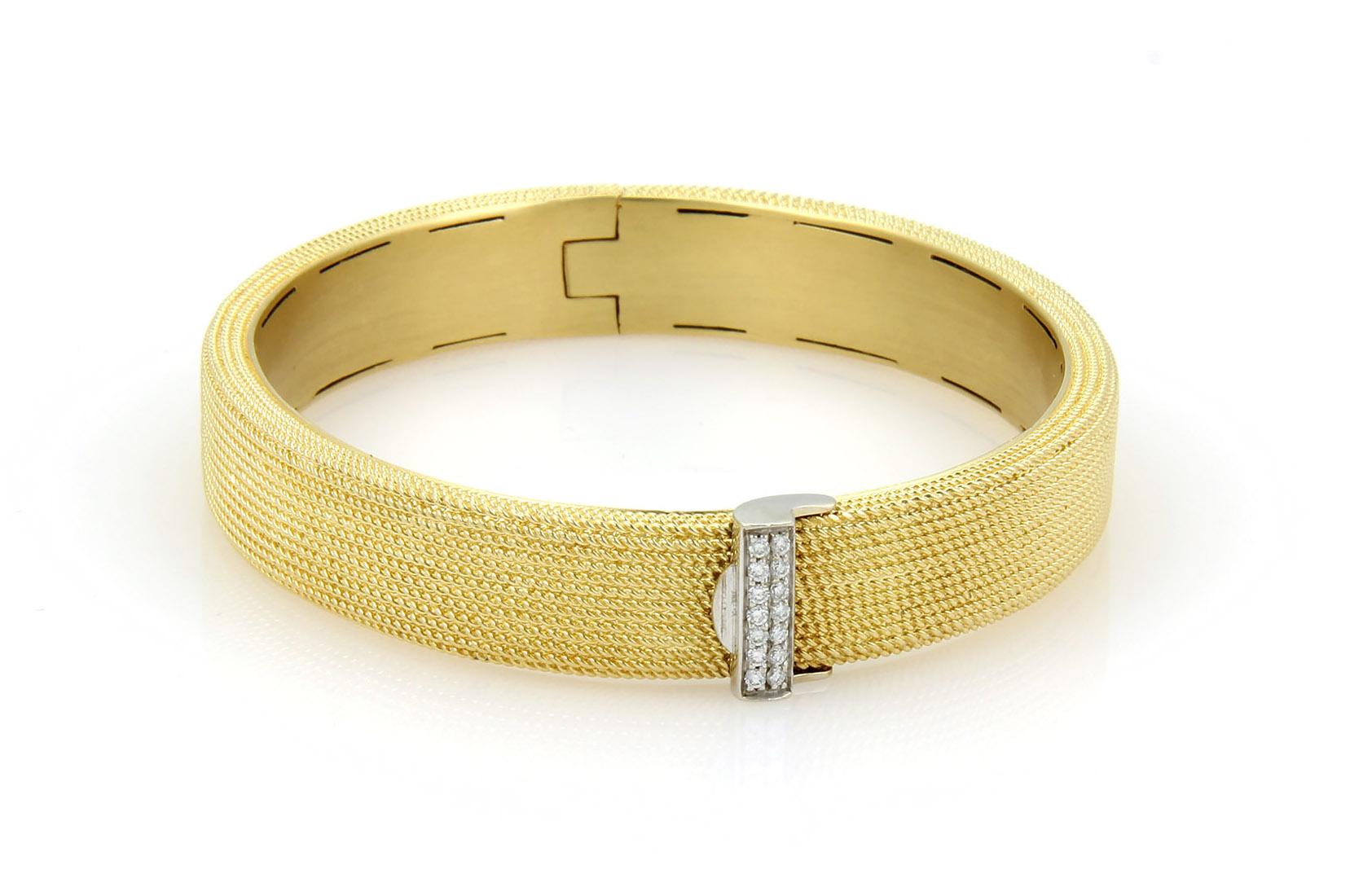 This is a magnificent medium width band bracelet from Roberto Coin, it is well crafted from solid 18k yellow gold with a buckle style clasp in white gold adorned with sparkling round cut diamonds. The band boast a beautiful fine wire textured finish