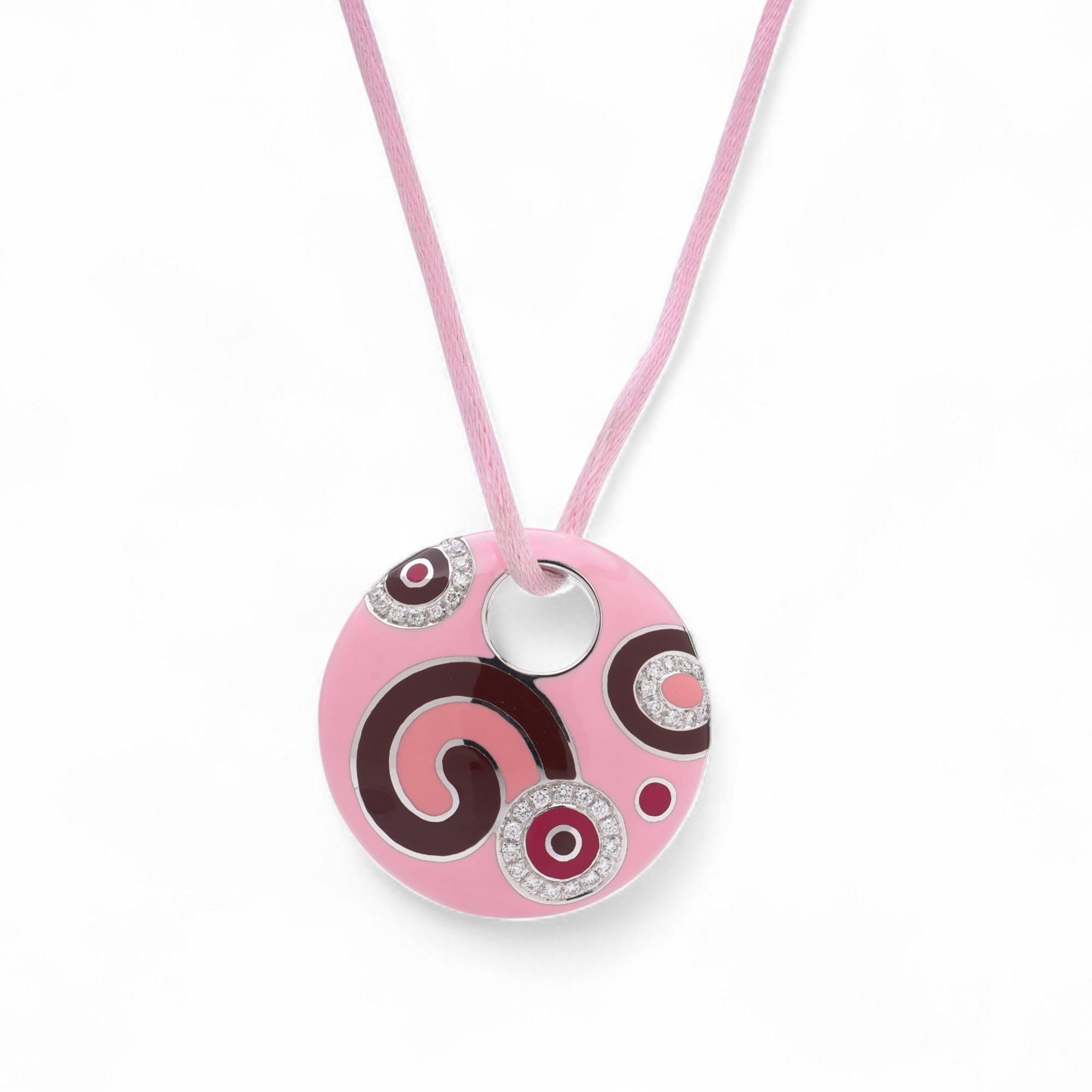 Una collana con ciondolo di Roberto Coin realizzata in oro bianco 18 carati. Il pendente circolare è decorato con dettagli in smalto rosa e incastonato con diamanti rotondi a taglio brillante. Inoltre, presenta un singolo zaffiro rosa rotondo con