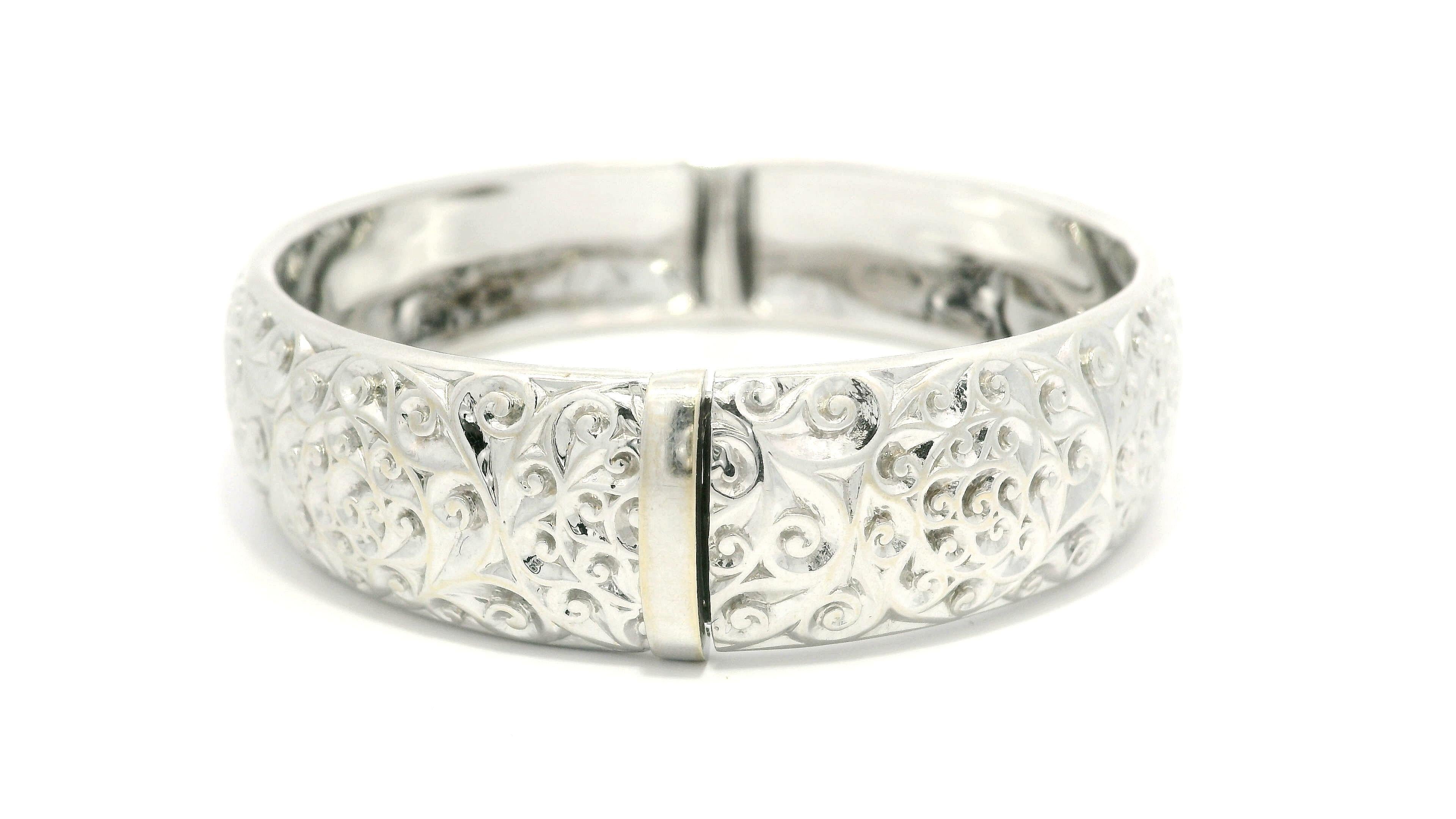 MATERIAL : Or blanc massif 18k - Pierre rouge pour la signature
Poids : 50,27 grammes
Type : Bracelet à charnière
Longueur totale : S'adapte confortablement jusqu'à 6.75