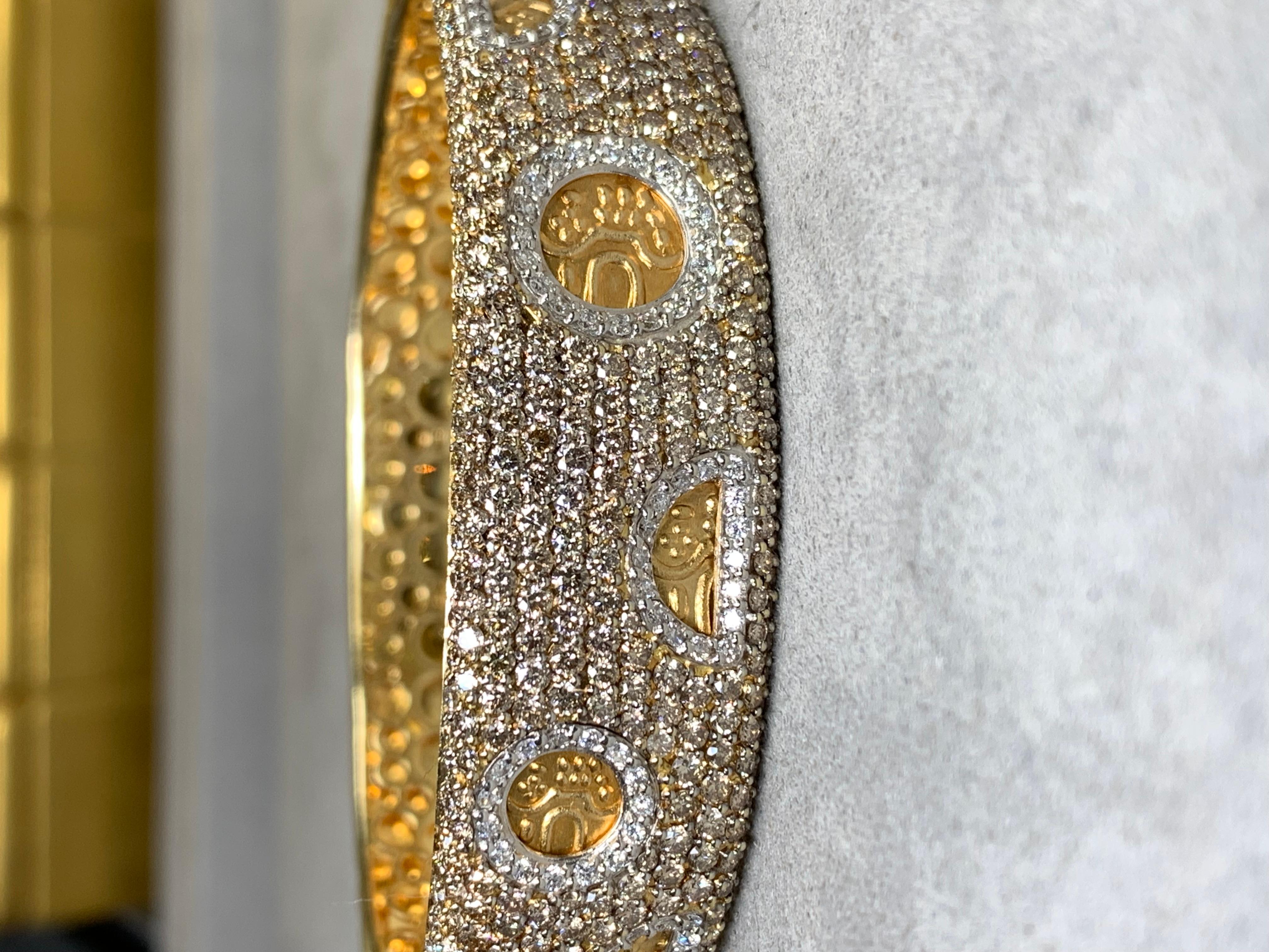 An impressive cuff bracelet by none other than Italian designer Roberto Coin. It is crafted in 18K yellow gold with the bottom portion exhibiting a carefully applied hammered finish with the top being pavé set with approximately 7ctw in natural