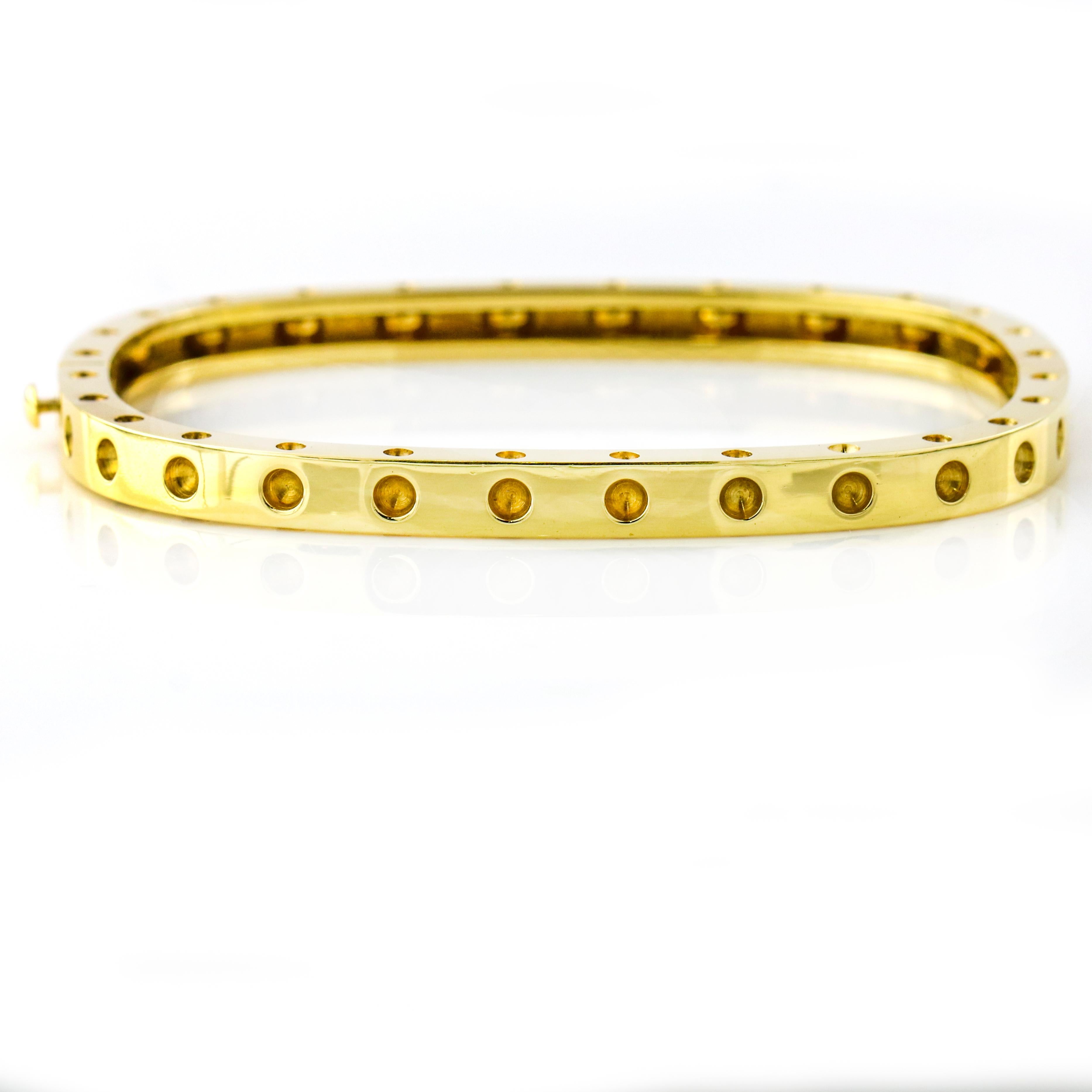 Roberto Coin 1-row Pois Moi hinged square bangle bracelet in 18-karat yellow gold. Signature ruby inside. Box clasp. Made in Italy. Retail $4,300.

Width, 10 mm
Size, Medium (Fits a wrist up to 6.25 inches.)