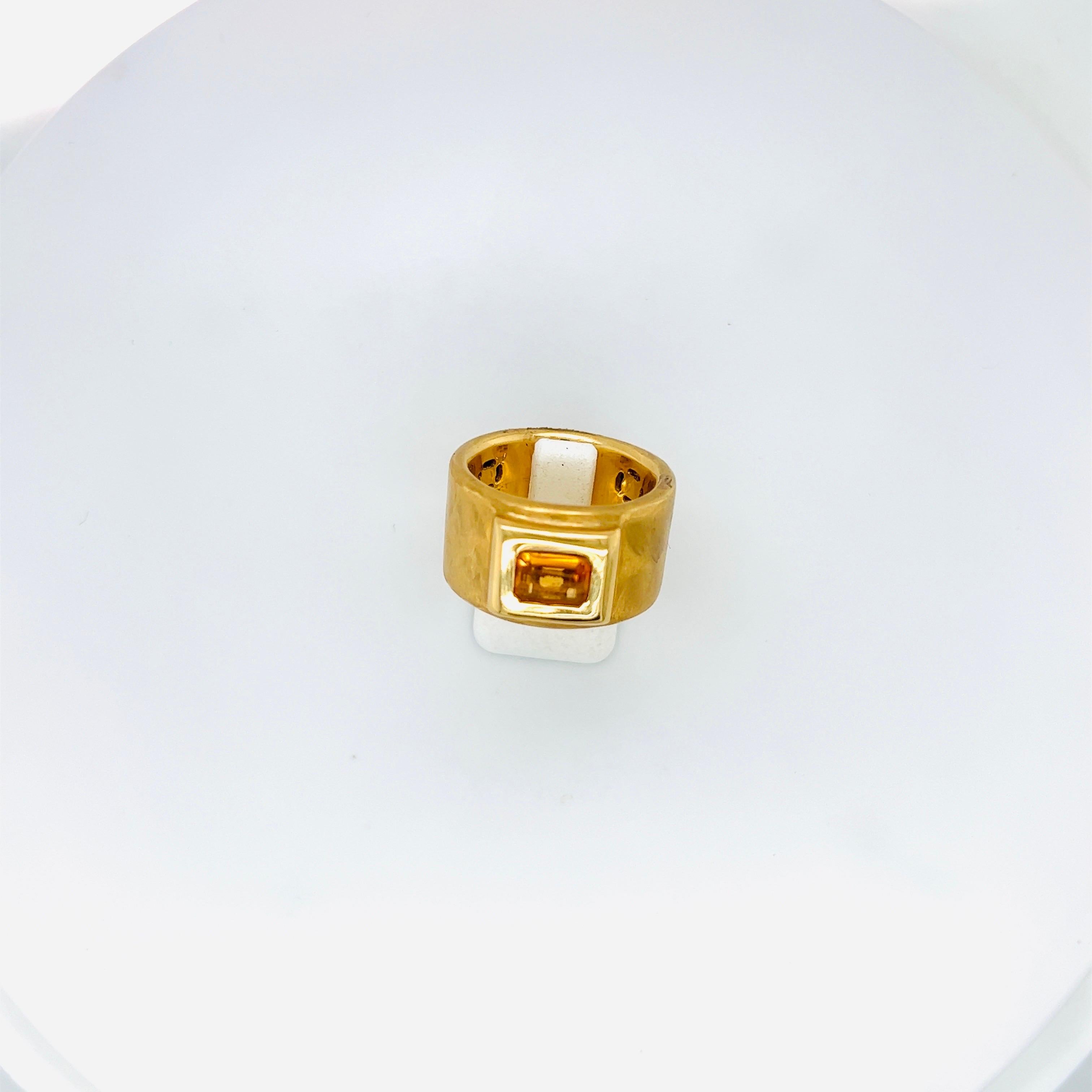 Dieser breite Ring aus 18 Karat Gelbgold wurde von Roberto Coin in Italien entworfen und mit einer satinierten Oberfläche gefertigt. Im Mittelpunkt des Rings steht ein Citrin im Smaragdschliff in einer erhöhten Fassung aus Gelbgold.
Gestempelt