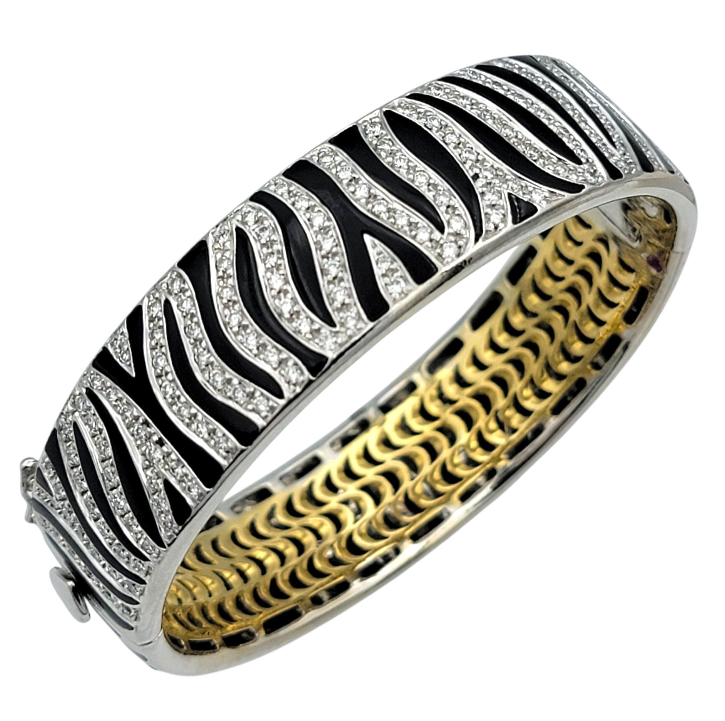 Esta impresionante pulsera brazalete de cebra Roberto Coin Animalier exhibe el característico estilo del diseñador para el lujo atrevido y el arte refinado. Elaborada en oro blanco y amarillo de 18 quilates, la pulsera presenta un llamativo motivo