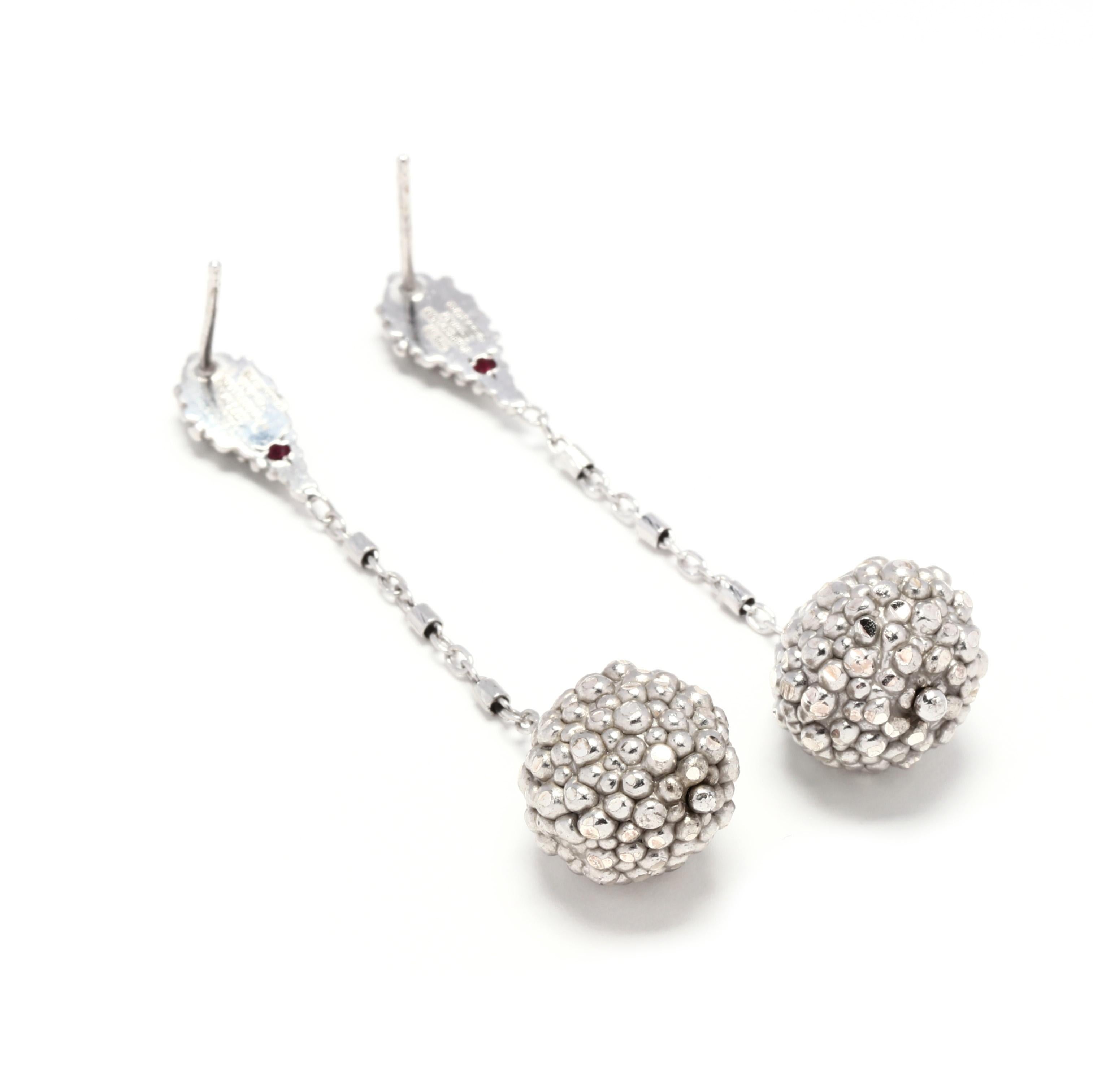 A pair of sterling silver ball dangle earrings, TFS by Roberto Coin. These earrings feature a beaded pear shape stud with a round cut ruby on the back suspending a large beaded ball dangle.



Length: 2.25 in.



Width: 1/2 in.



Weight: 7.1 grams