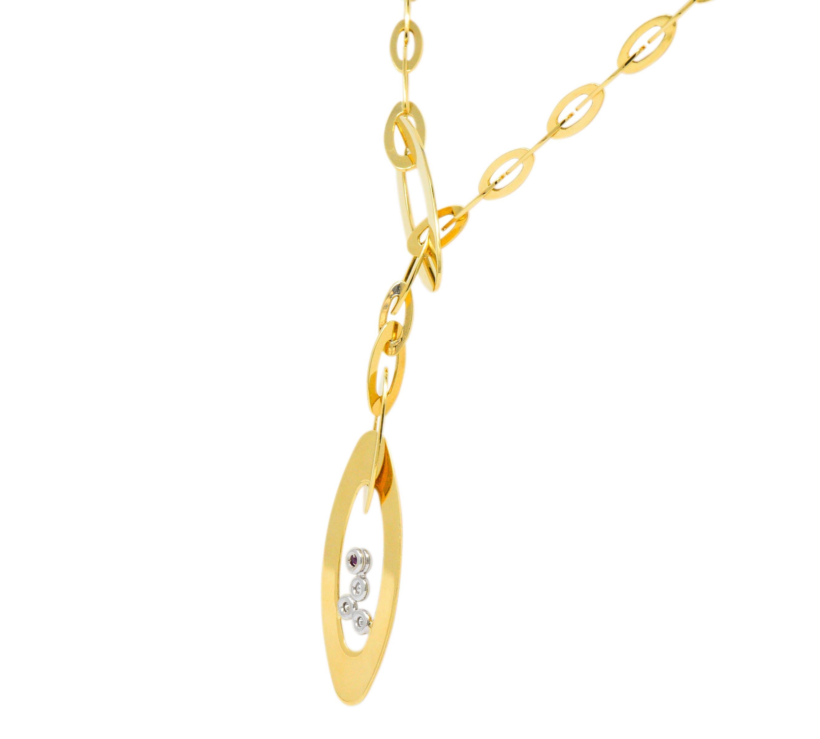 Lariat style necklace comprised of polished gold oval links 

Terminating as two oversized oval links, one threaded through the other

Centering four white gold bezels accented by four round brilliant cut diamonds weighing in total approximately
