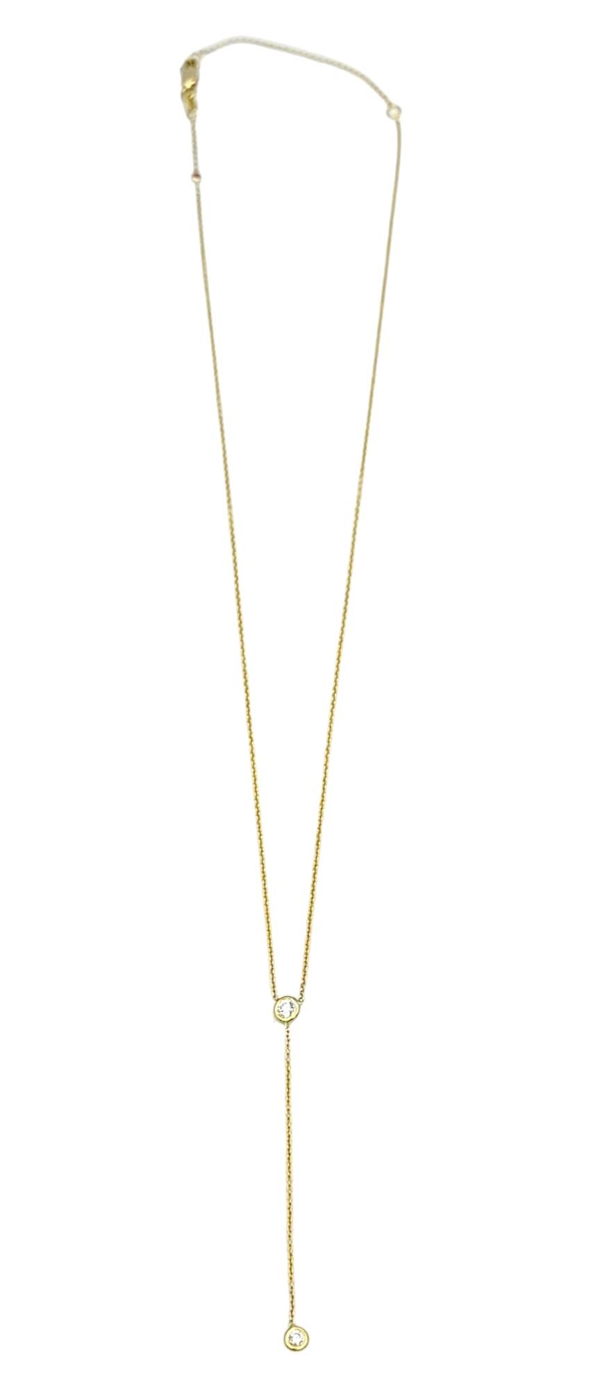 This stunning Roberto Coin 'Diamonds By The Inch' lariat necklace, crafted in opulent 18 karat yellow gold, exudes timeless elegance and sophistication. This exquisite necklace features two bezel-set round diamonds delicately spaced along the drop