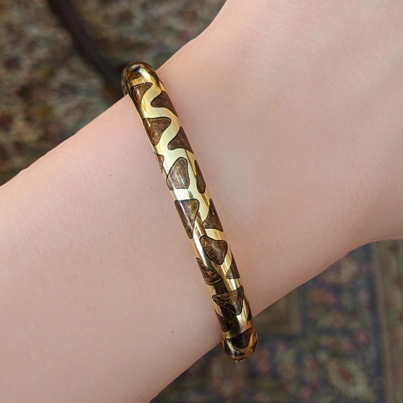 Estate Roberto Coin Giraffe Enamel Bangle in 18k Yellow Gold 

Enamel and 18k Yellow Gold Giraffe Bangle features a Hinged bangle with Reddish Brown Enameling set in 18k Yellow Gold in Giraffe Print, by Roberto Coin. 

Bangle fits a 6.25 inch wrist