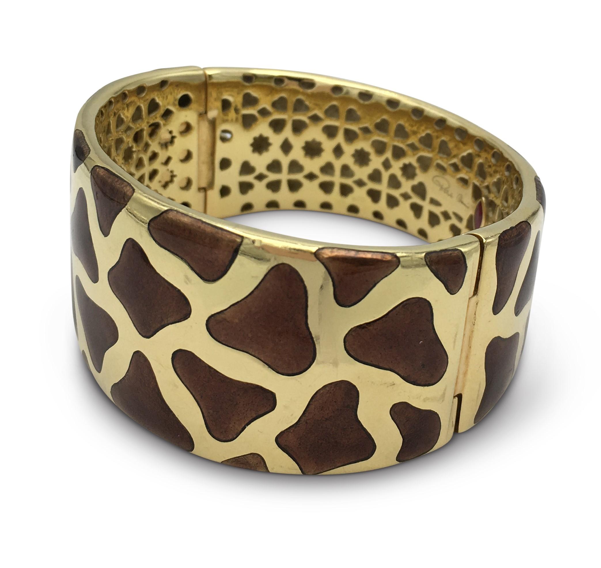 Authentic Roberto Coin bangle crafted in 18 karat yellow gold featuring brown enamel inlay resembling that of a giraffe. Hinge bracelet fits up to a 6 1/2 inch wrist comfortably. Tapered width of 1 1/4