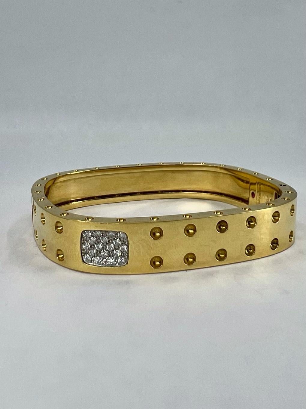 An iconic Pois Moi bangle by Roberto Coin, made of 18k gold, features diamond.
It’s a two-row version of a Pois Moi bracelet. The bangle is decorated with the tiny craters set on the surface and the edge of the bracelet. These dots placed on