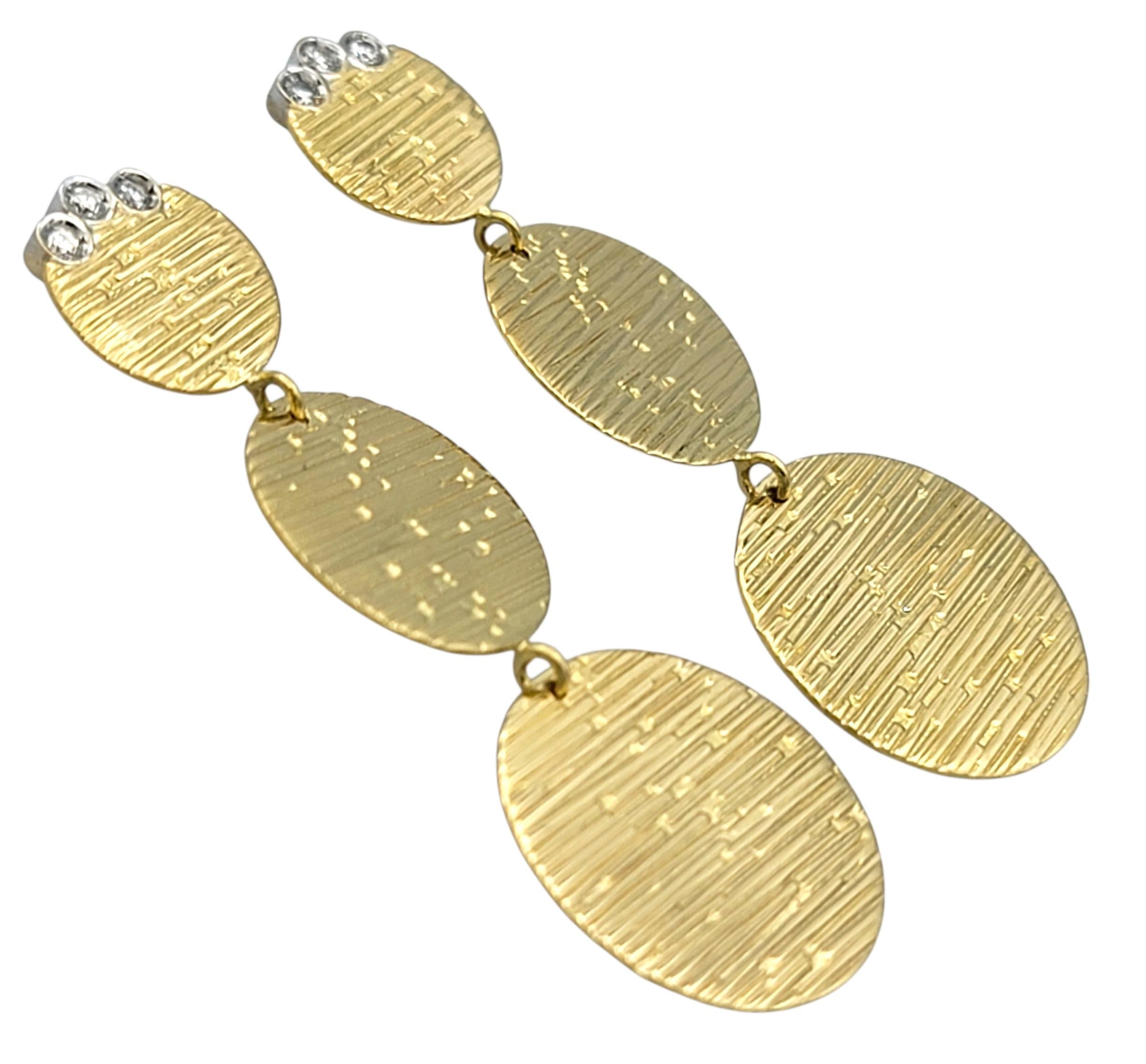 Ces remarquables boucles d'oreilles de Roberto Coin présentent un design à la fois audacieux et élégant avec trois disques en cascade en or jaune 18 carats radieux. La finition martelée de chaque disque ajoute de la texture et de la dimension,