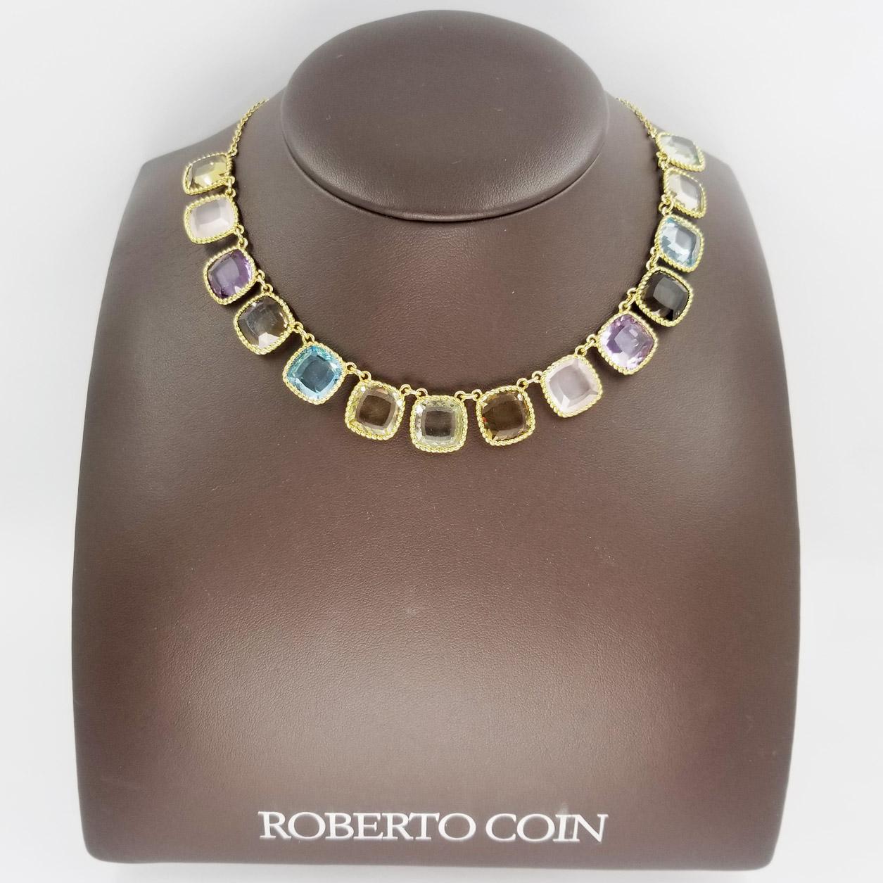 18 karat yellow gold necklace from the Roberto Coin Ipanema collection. The bib style necklace, model number 915954AY18MX, features fourteen cushion cut lemon citrine, smokey quartz, citrine, prasiolite, rose quartz, amethyst, and blue topaz. It is