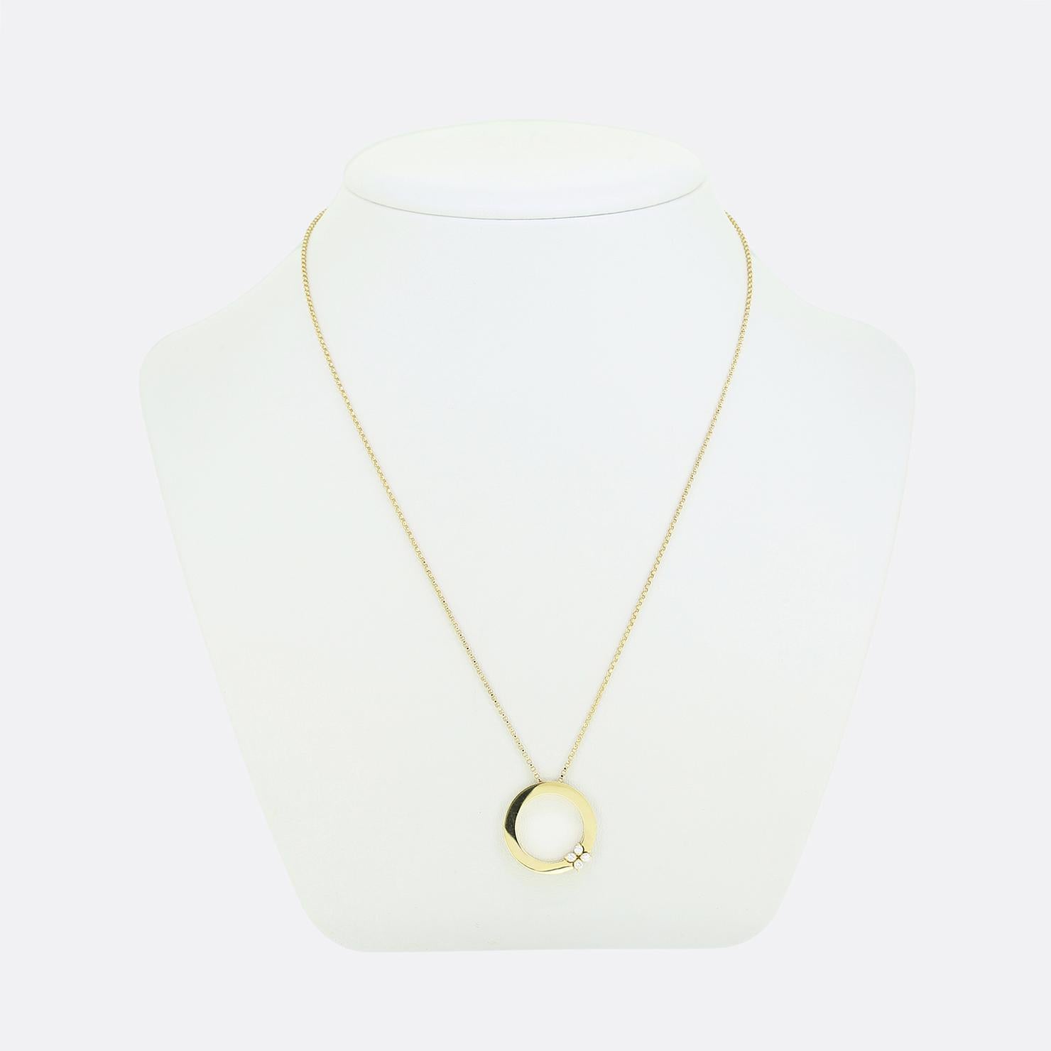 Aquí tenemos un elegante collar del estimado diseñador de joyas italiano Roberto Coin. El colgante presenta un diseño circular muy pulido elaborado en oro amarillo de 18 ct. Adorna el círculo abierto un delicado motivo floral formado por cuatro