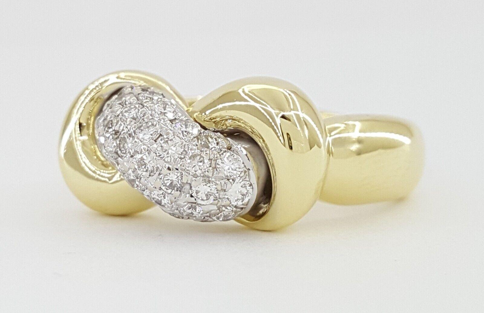 Roberto Coin Bague à nœud infini en or jaune 18 carats sertie de diamants.
La bague pèse 7,4 grammes, taille 6,5, 9,3 mm de large, 6,5 mm de haut, il y a 32 diamants ronds naturels de taille Brilliante pesant environ 0,64 ct, de couleur F-H, de