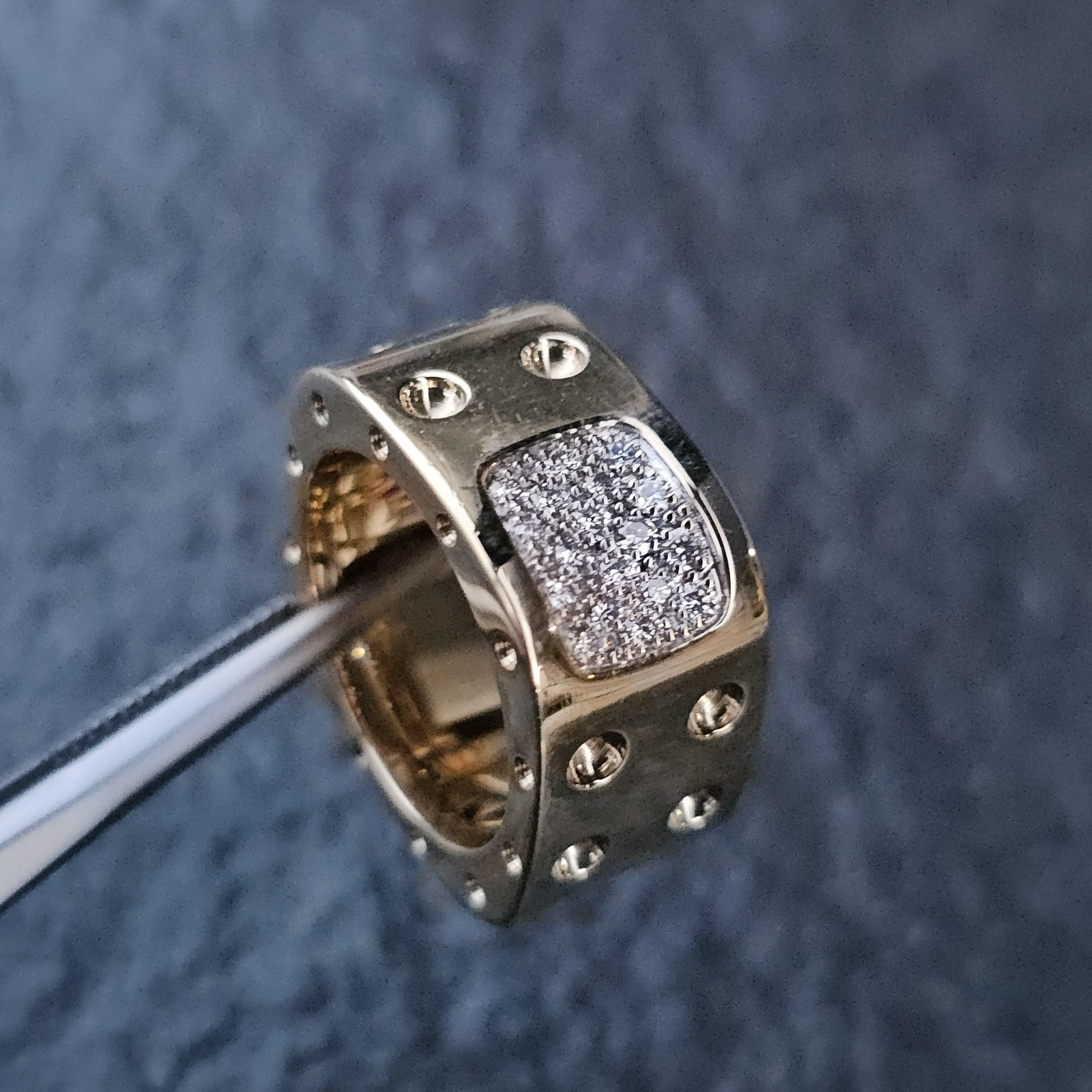 Questo è un sorprendente anello a fascia a doppia fila di Roberto Coin Pois Mois, realizzato in oro 18 carati. Il design è caratterizzato da un gruppo rettangolare di diamanti bianchi che aggiungono un tocco di brillantezza al pezzo. La fascia è