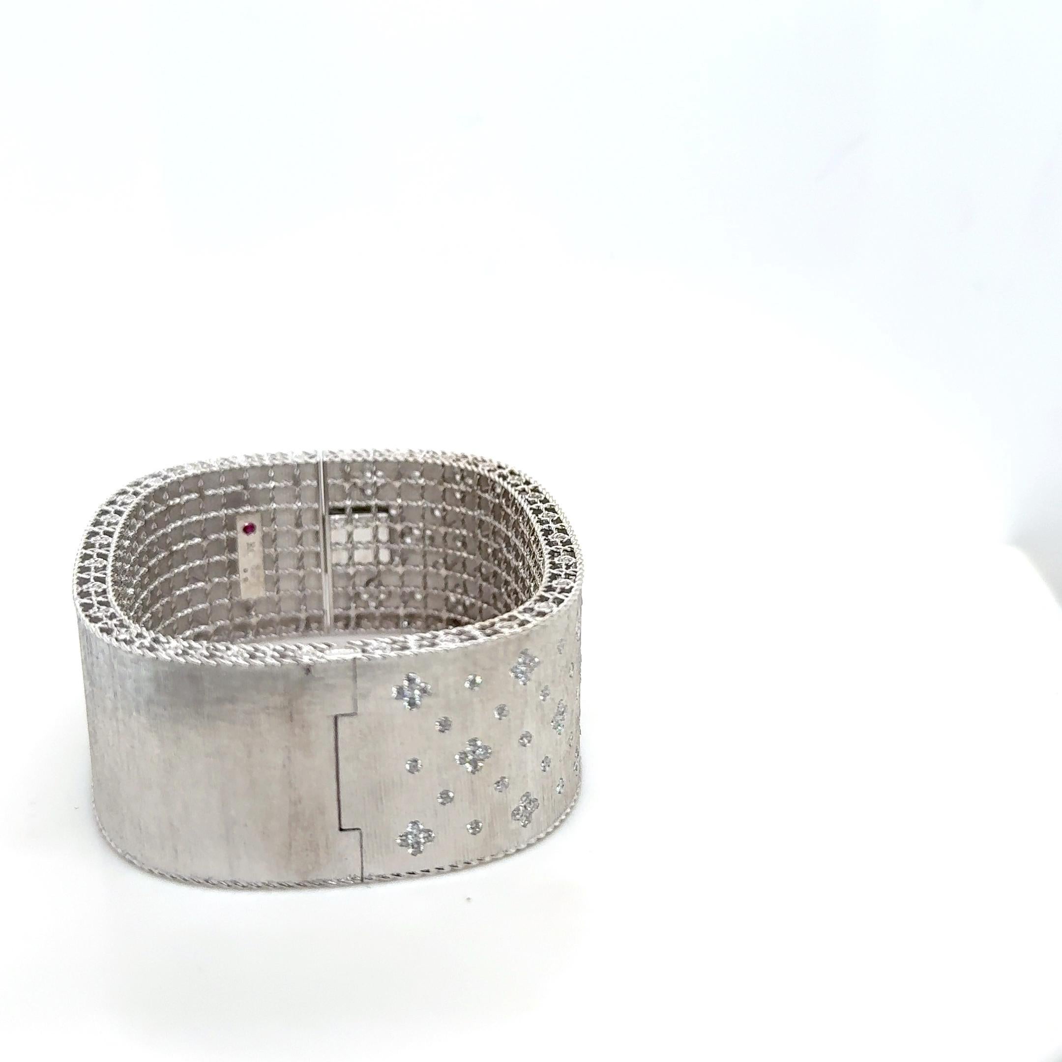 Este lujoso brazalete Roberto Coin Princess Fleur De Lis está bellamente elaborado en oro blanco de 18 quilates con un refinado acabado satinado, mostrando el arte característico de la marca. La pulsera está adornada con 142 diamantes redondos talla