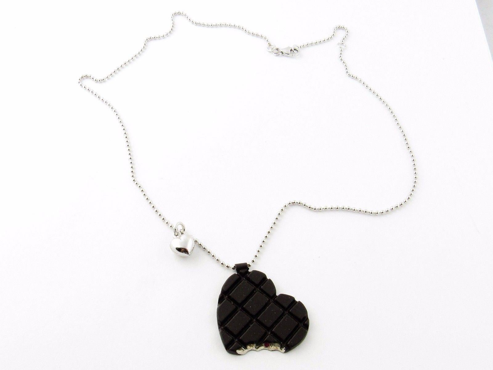 Roberto Coin Sterling Silver Chocolate Heart With Bite Necklace

This necklace is authentic Roberto Coin 

The chocolate rubber cookie heart has the signature RC ruby in the bite and is marked Roberto Coin on back.

Sterling necklace is marked 925