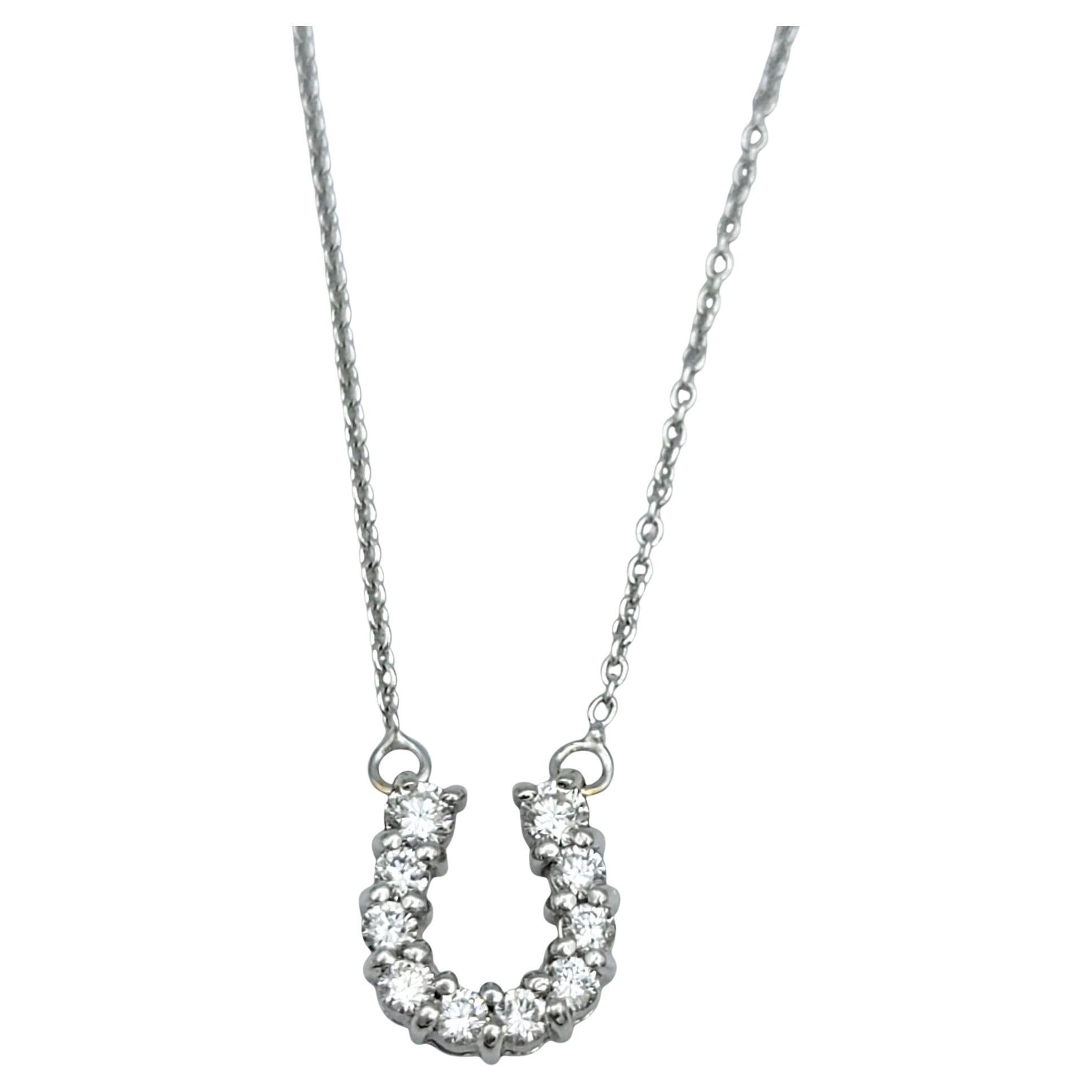 Questa affascinante collana di Roberto Coin è caratterizzata da un pendente a ferro di cavallo tempestato di diamanti sospeso a una delicata catena, il tutto realizzato in oro bianco 18 carati. Il ferro di cavallo aperto brilla di diamanti rotondi