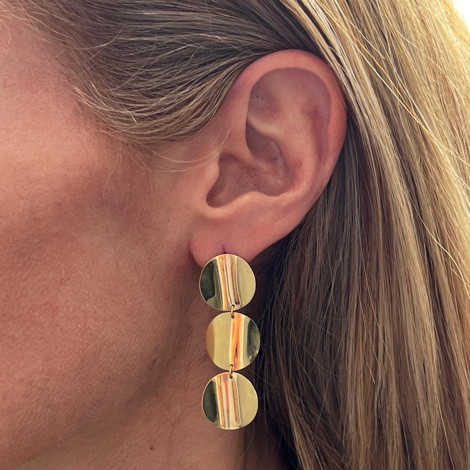 Roberto Coin disc drop earrings crafted in 18 karat yellow gold. The flat disc earrings are lightweight for everyday wear and measure 2.00 inches in length. Roberto Coin's hallmark ruby is on the back. 