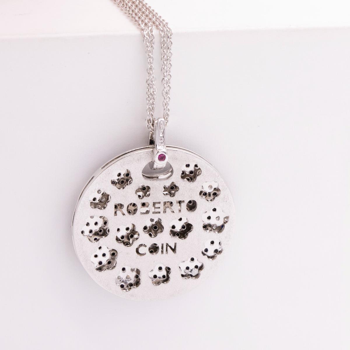 An 18 karat white gold, diamond, black diamond, and ruby Roberto Coin Fantasia pendant suspended from a Roberto Coin white gold double cable chain, the bale also set with diamonds. The reverse of the pendant is intricately perforated featuring the