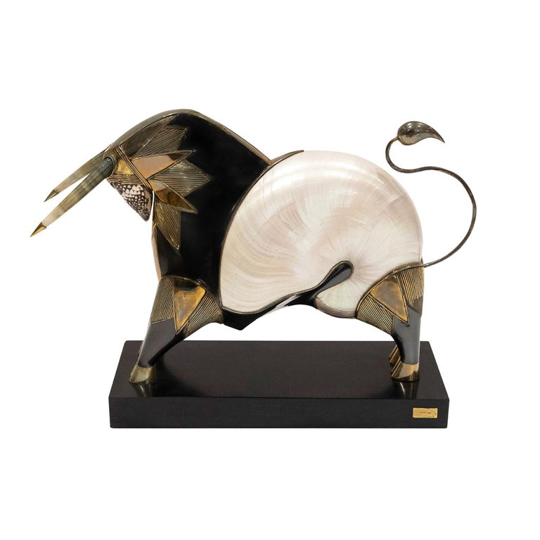 Exquisite unique sculpture of a stylized bull composed of sea shells with etched brass elements and an ebonized base by Roberto Estevez, American 1980's (signed “ESTEVEZ” on plaque on base). The use of sea shells to compose parts of the bull is