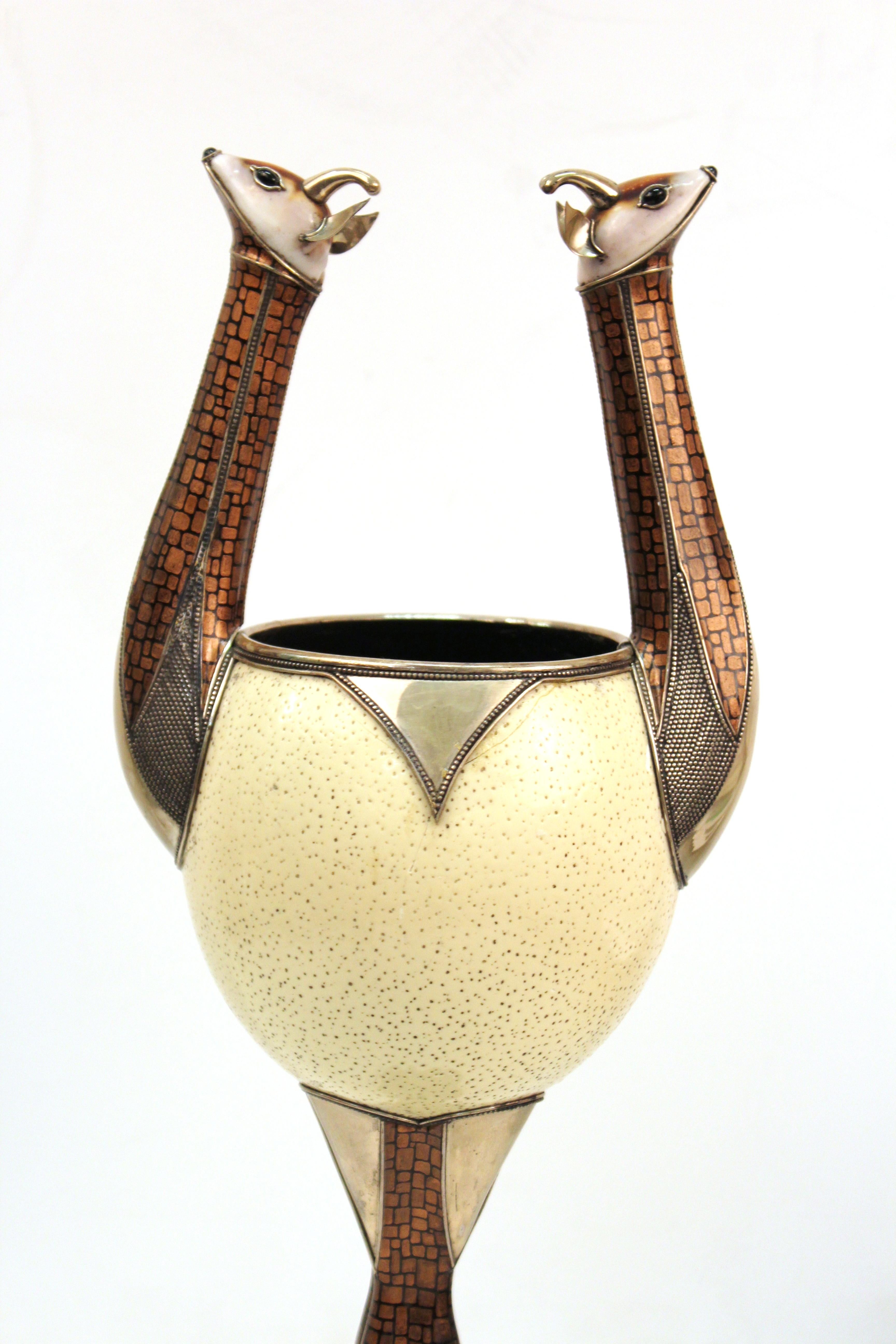 Modern sculptural ostrich egg cup or urn with animal handles. The piece has deer head handles and hooved feet, with hammered metal, textured and painted surfaces. The piece was likely made in the circa 1970s and has a small plate marked 'Estevez' on