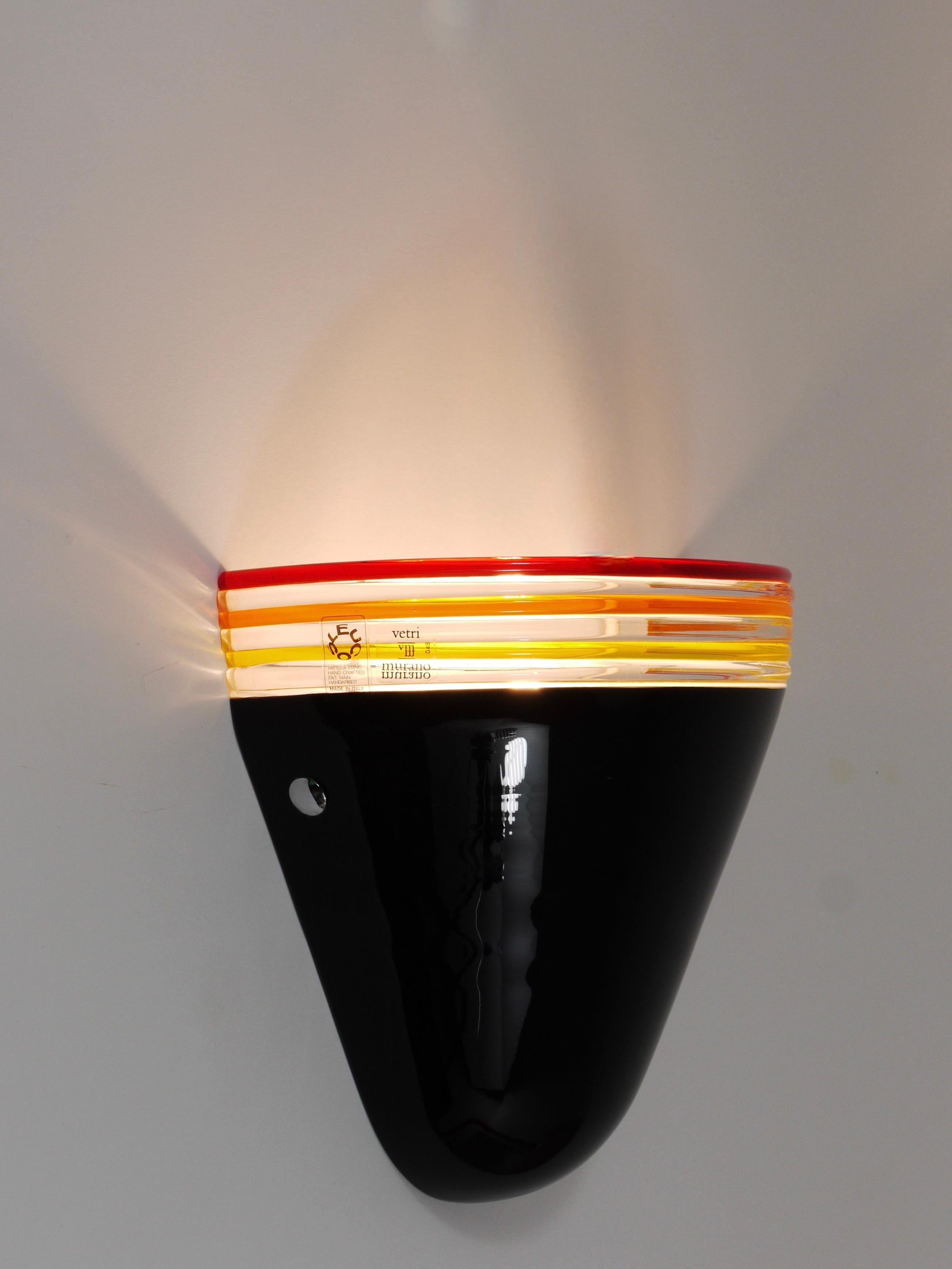 One single wall light from the 1980s, designed by Roberto Pamio and Renato Toso for Leucos in Italy.  Stripped down to its essential elements, this lamp consist of just two components: The mounting hardware made of white metal and a mouth-blown