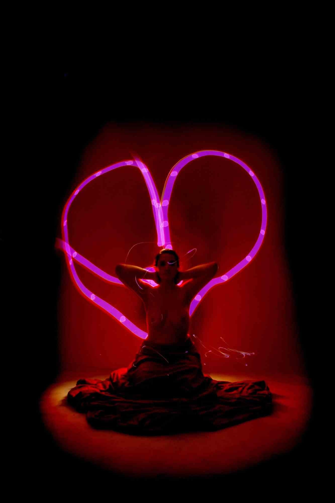 Light-Painting-Technik, die in einem völlig dunklen Studio realisiert wird, in dem der Fotograf manuell mit einer Taschenlampe "malt".  mit verschiedenfarbigem Licht, den Motiven und dem Hintergrund. Digitalkamera, chemischer