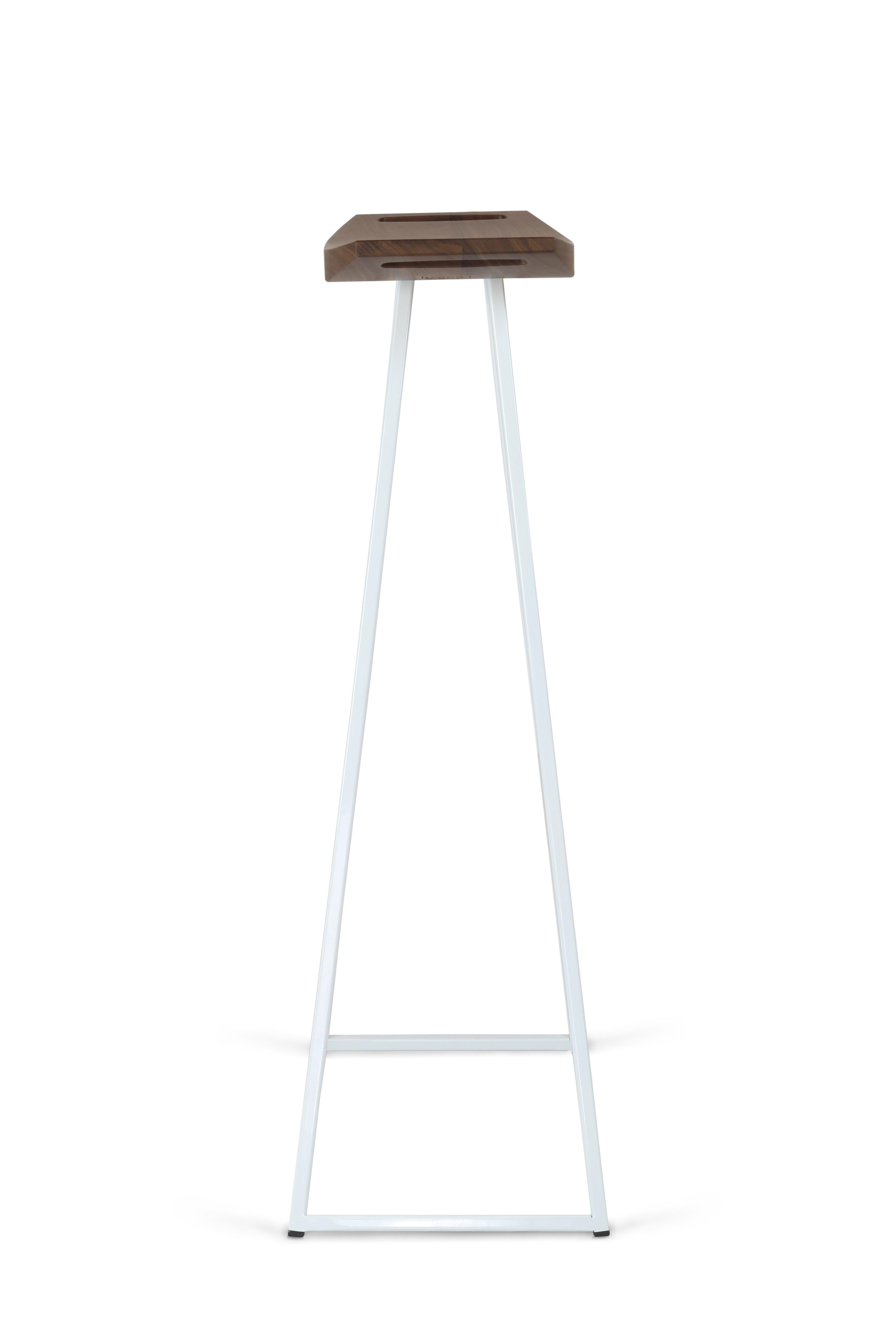 Dieser elegante Hocker hat einen dünnen, geschnitzten Holzsitz, der auf einem Stahlrohrsockel ruht. Der elegante Sitz ist geschwungen und bietet nahtlosen Komfort, während er eine beeindruckende, sich kreuzende diagonale Akzenteinlage aufweist.