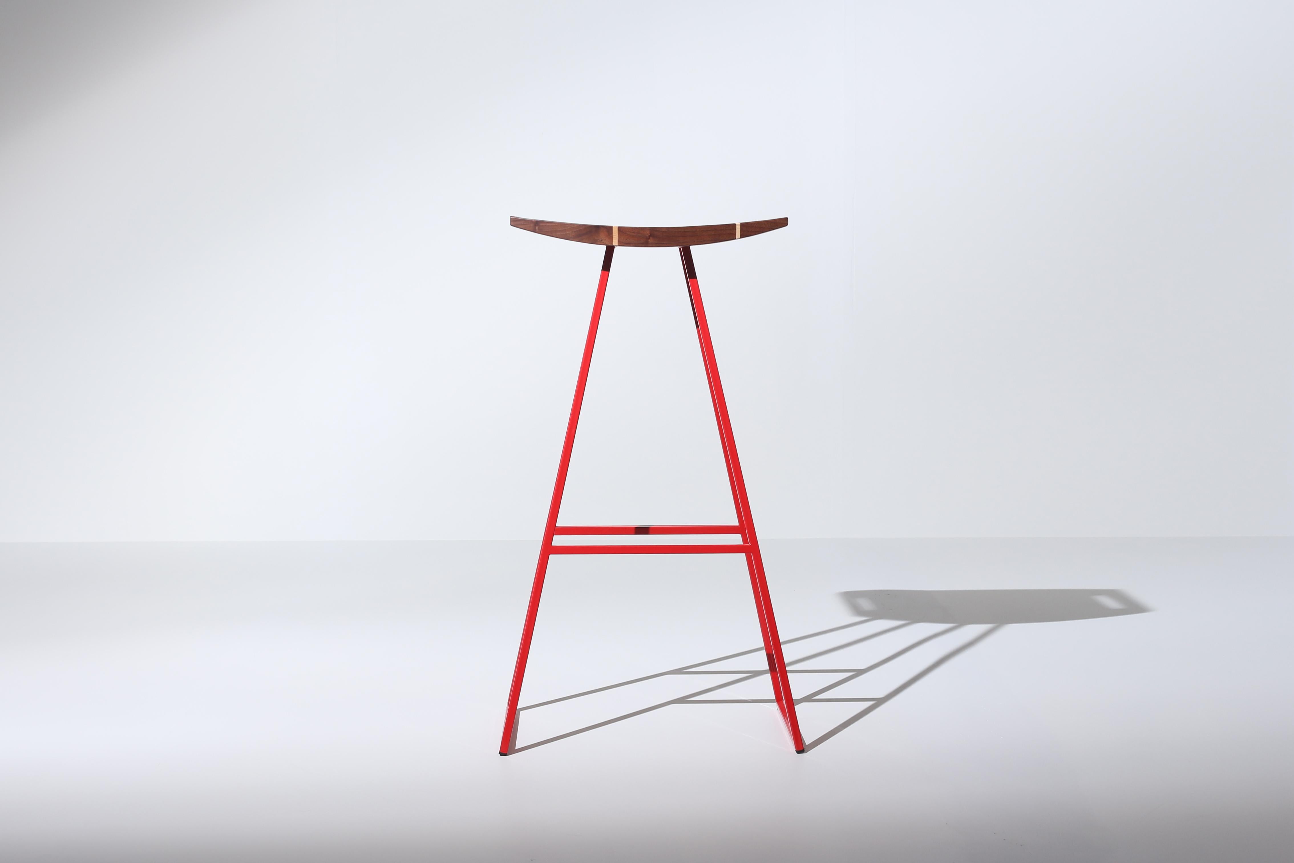 This sleek stool has a thin carved wooden seat that rests on a steel tubing base. The elegant seat is curved for seamless comfort while displaying a stunning intersecting diagonal accent inlay. This eye-catching and durable piece will make any