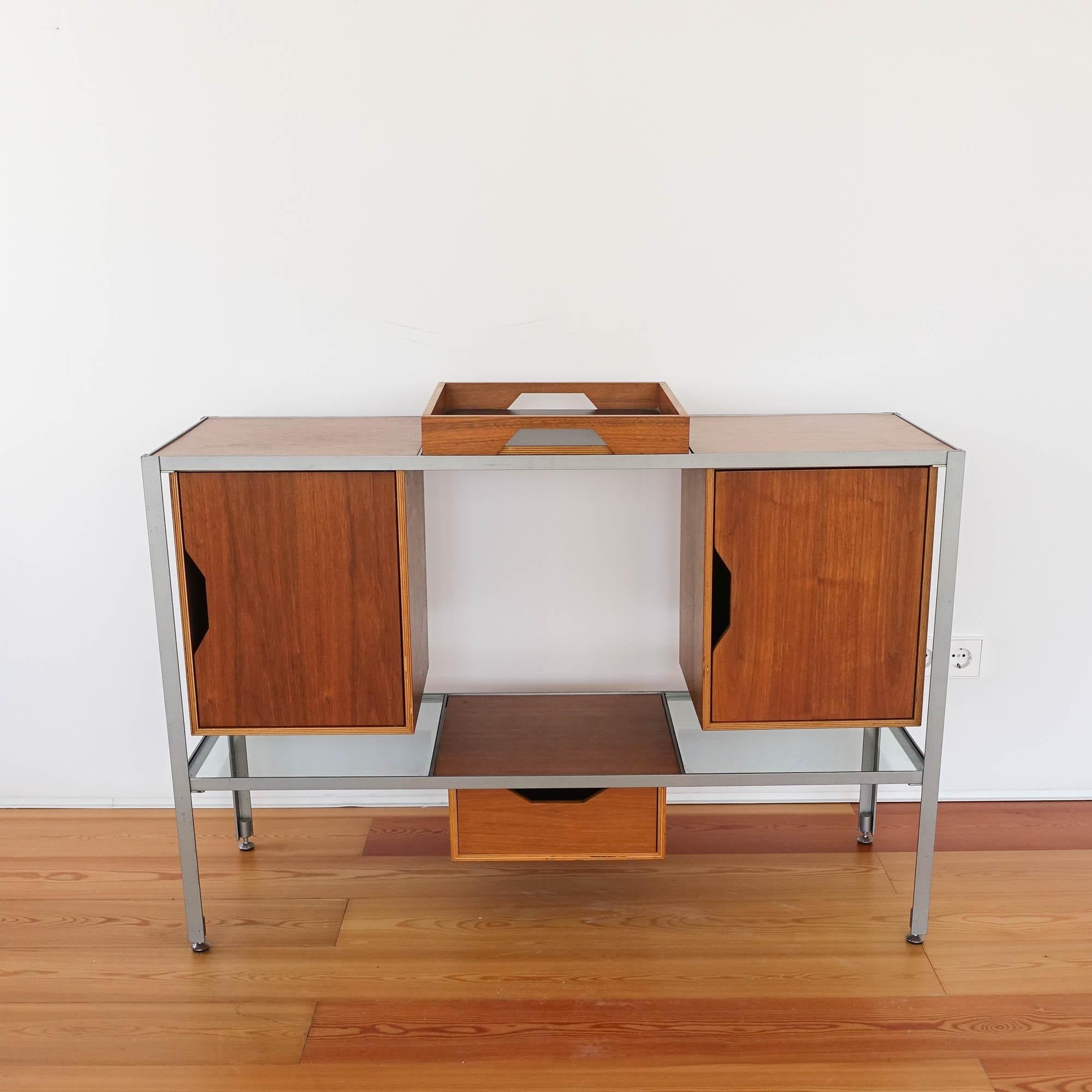 This sideboard was designed by Robin Day during the 1950's and reissue by Habitat, in UK. It is a modular piece were each component can be combine as desired, offering a thoughtful range of storage and display surfaces. It features a metal frame