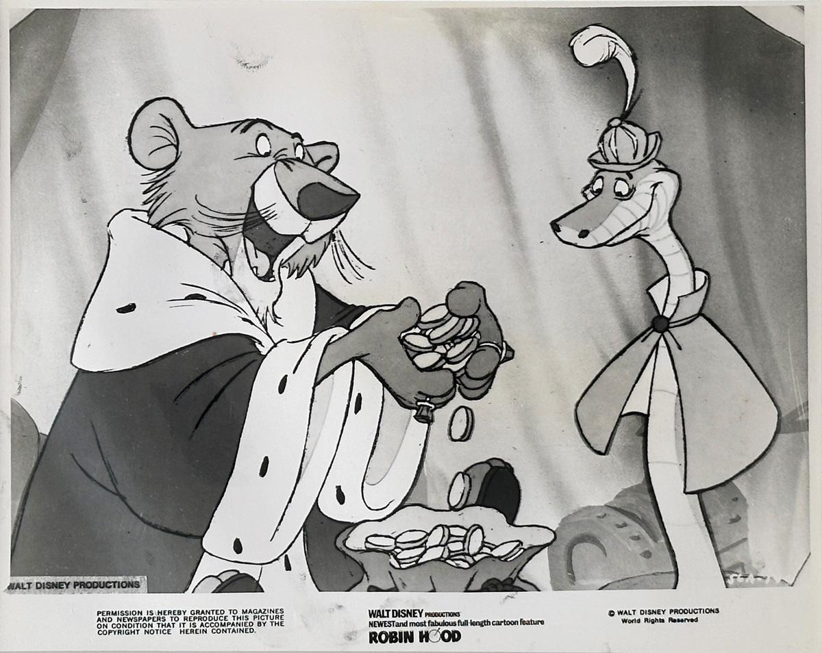 Photo publicitaire originale Disney 8x10 inches pour Robin des Bois (1973) avec une superbe image du Prince Jean et de Sir Hiss.

Les photos de publicité (film/production) ont été créées pour aider les studios à promouvoir leurs nouveaux films. Les