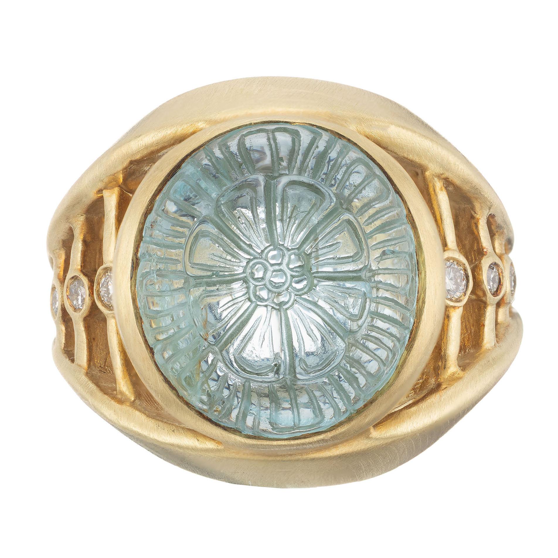 Robin Rotenier 18k yellow gold brush finish ring set with a carved dome aquamarine with diamond accents.

1 carved dome cabochon blue aquamarine, approx. 5.30cts
8 round brilliant cut diamonds G VS, approx. .12cts
Size 7 and sizable
18k yellow