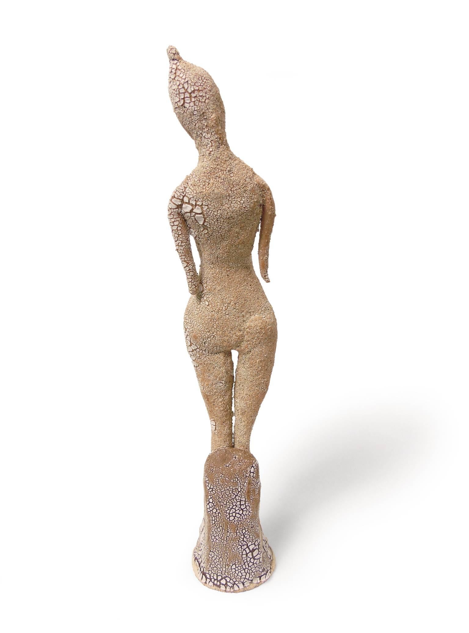 An eroded form and crackled surface add mystique to Standing Goddess by Robin Whiteman. This female figure is off-kilter. Her hands are missing and the white glaze is crackled to the point of looking sand-like. Robin Whiteman is known for her