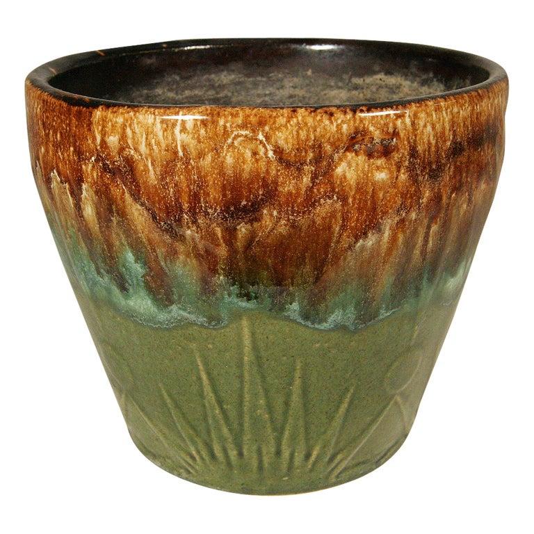 These vintage jardinières by the Robinson Ransbottom Pottery Company (known as RRPC) are sold as a pair with a large and one small vessel. These stoneware pots feature a green, brown and tan glaze with a dark brown interior and unglazed bottom. The