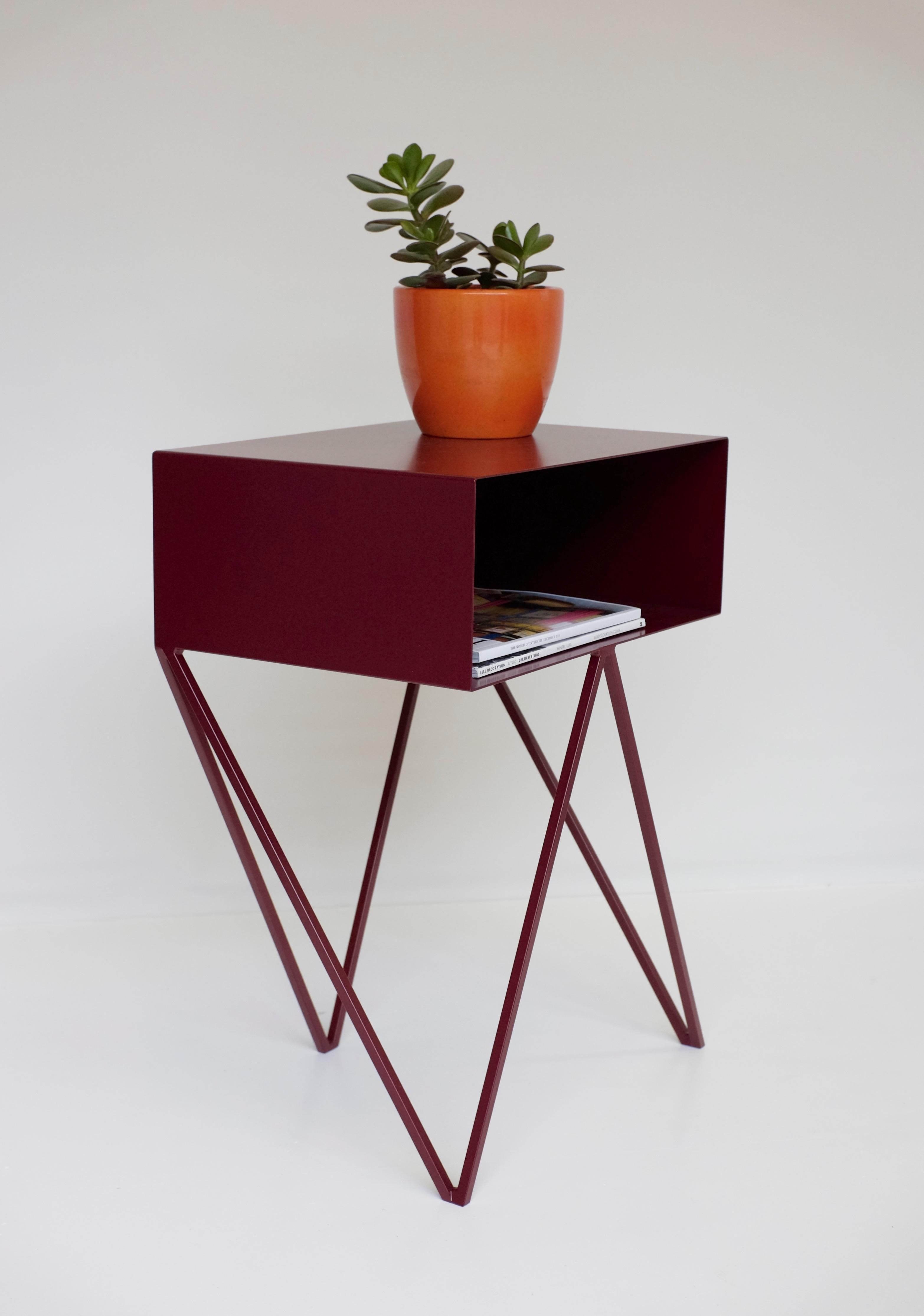 Our all-time best-seller the Robot side table features an open shelf on zig zag legs. A fun and functional design made of solid steel, powder-coated in burgundy or beetroot, as we like to call it. The clean lines look great against period details as