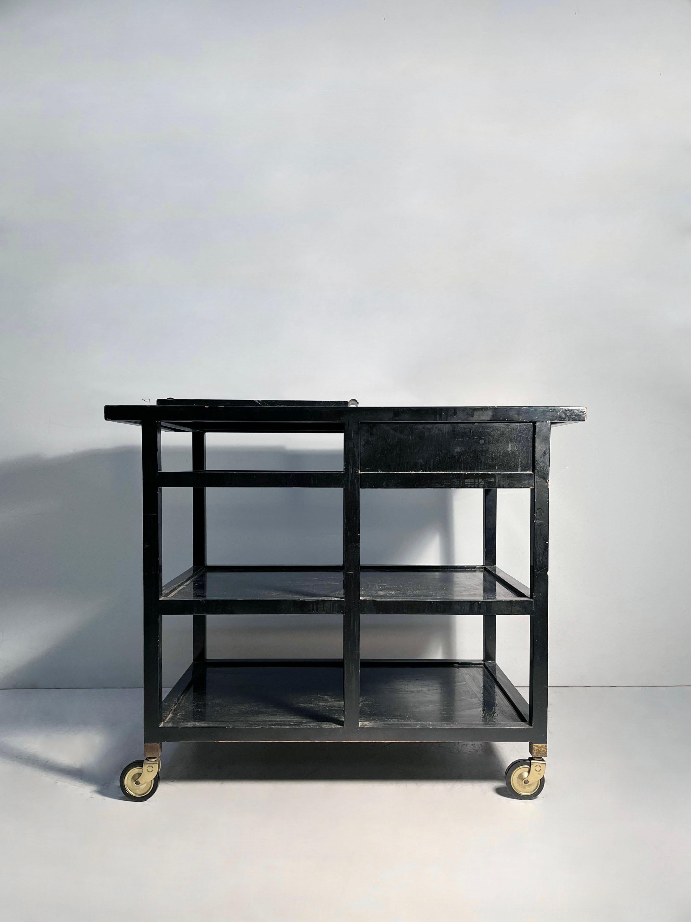 Robsjohn Gibbings Cart for Widdicomb in an Original Black Lacquer Finish. 
The sliding and removable black tray with brass handles is included.

The wheels need a minor adjustment repair as one of the stems that slide into leg is slightly bent. very